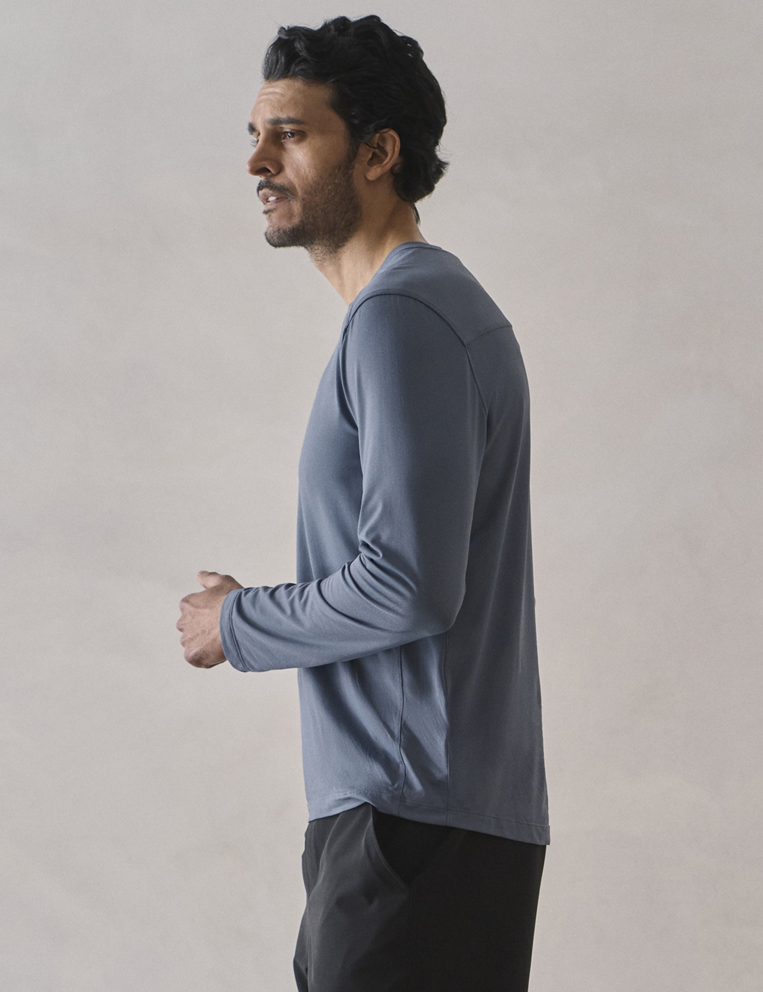 Side profile upper-body view of man wearing Adventure Performance Long-Sleeve Tee in Portal Blue from AETHER Apparel.