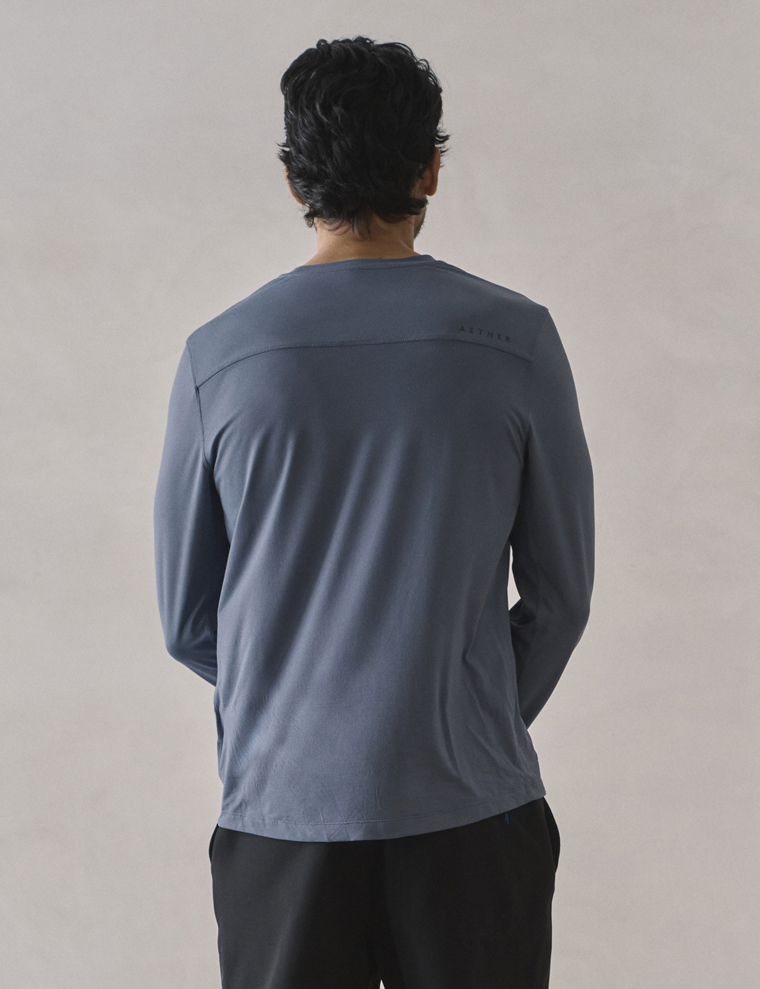 Rear upper-body view of man wearing Adventure Performance Long-Sleeve Tee in Portal Blue from AETHER Apparel.