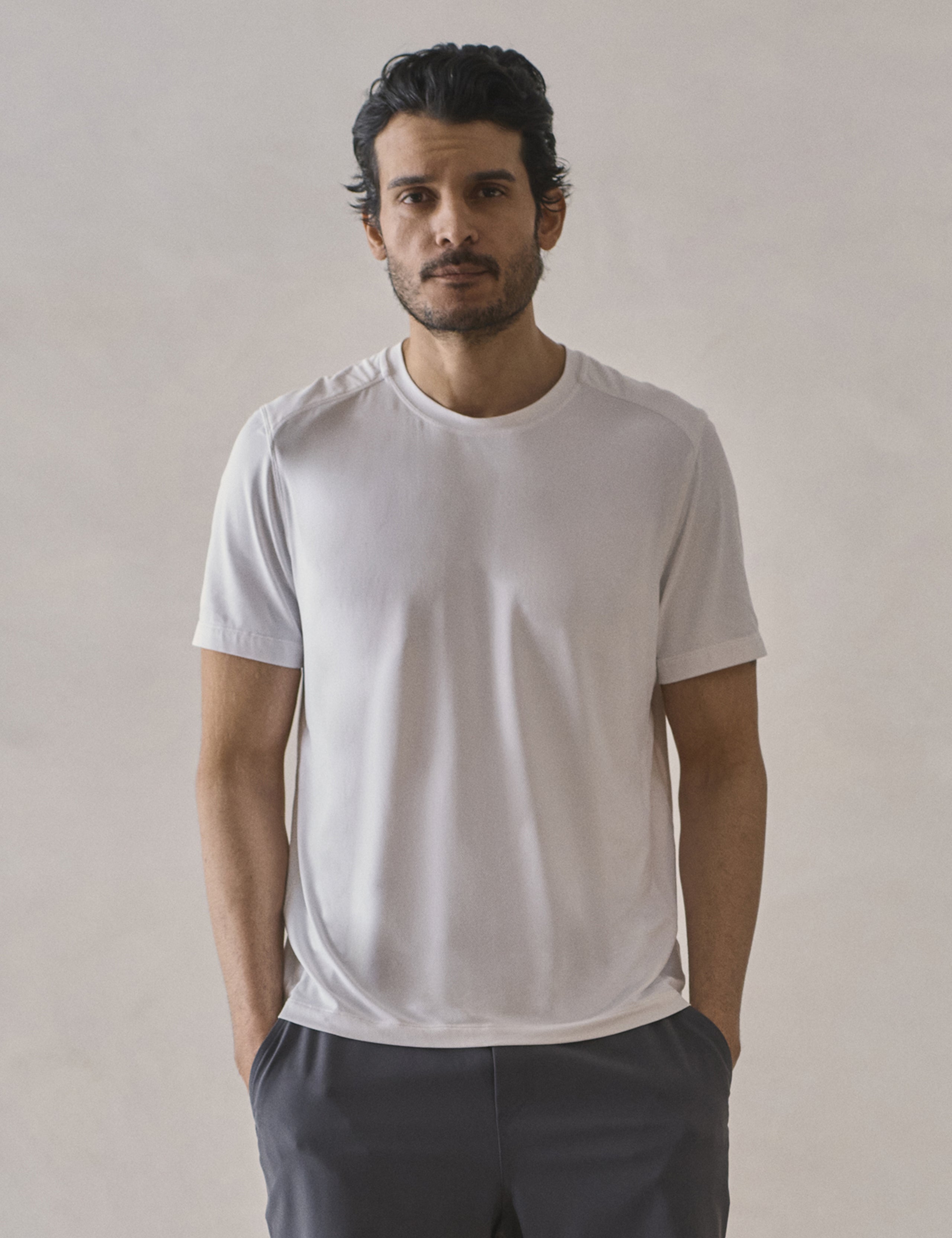 Front upper-body view of man wearing Adventure Performance Short-Sleeve Tee in White from AETHER Apparel.
