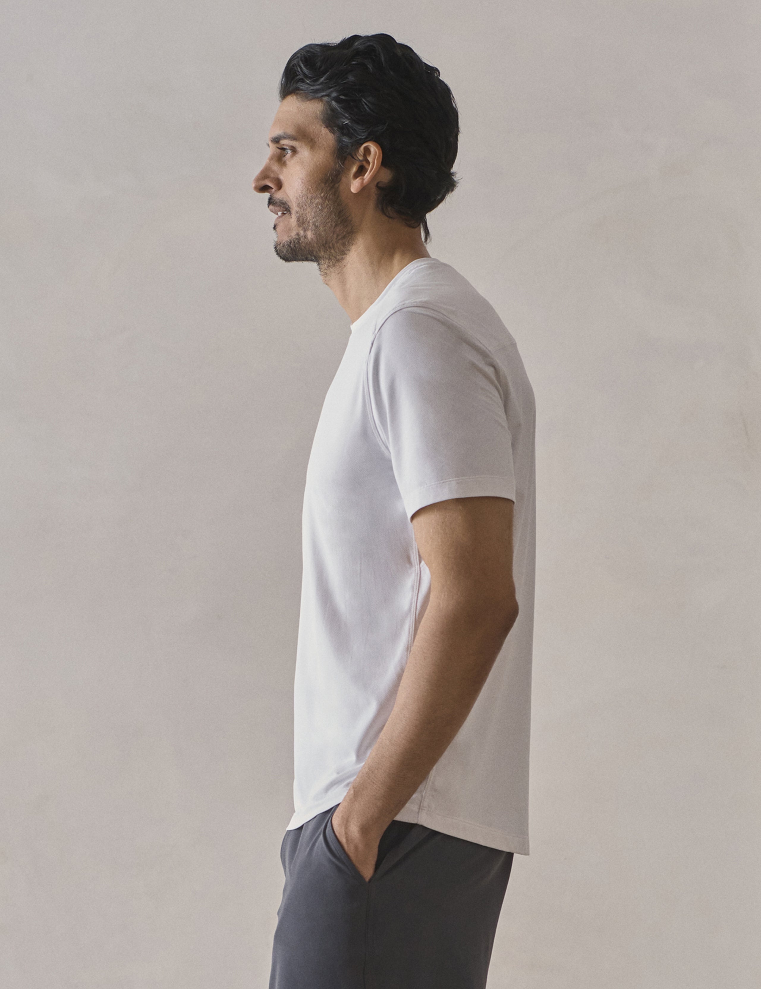 Left side profile upper-body view of man wearing Adventure Performance Short-Sleeve Tee in White from AETHER Apparel.
