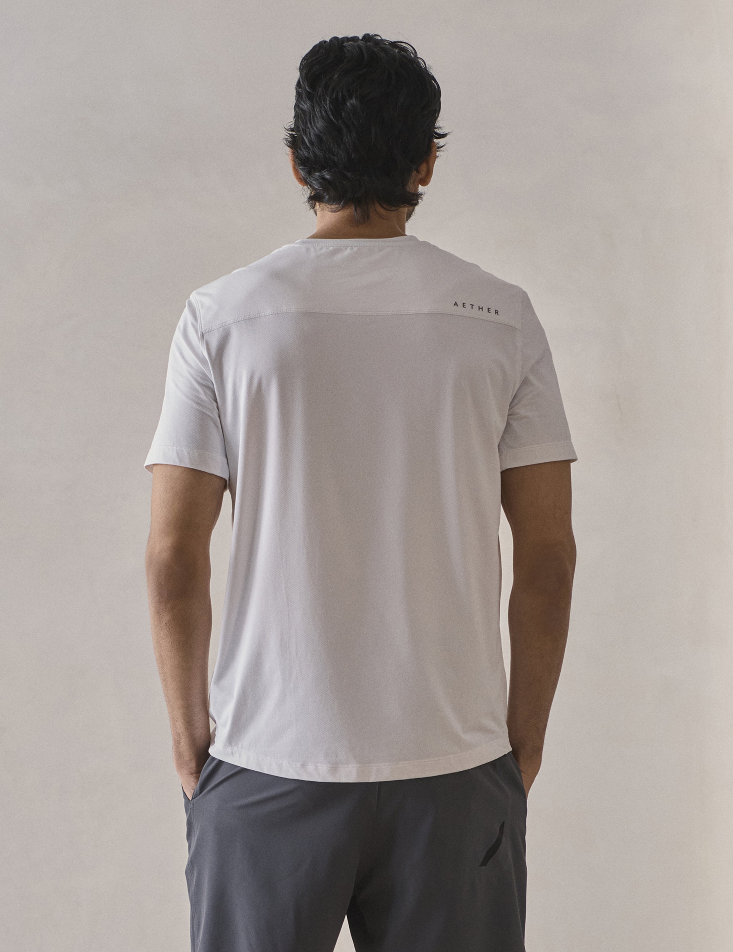 Rear upper-body view of man wearing Adventure Performance Short-Sleeve Tee in White from AETHER Apparel.