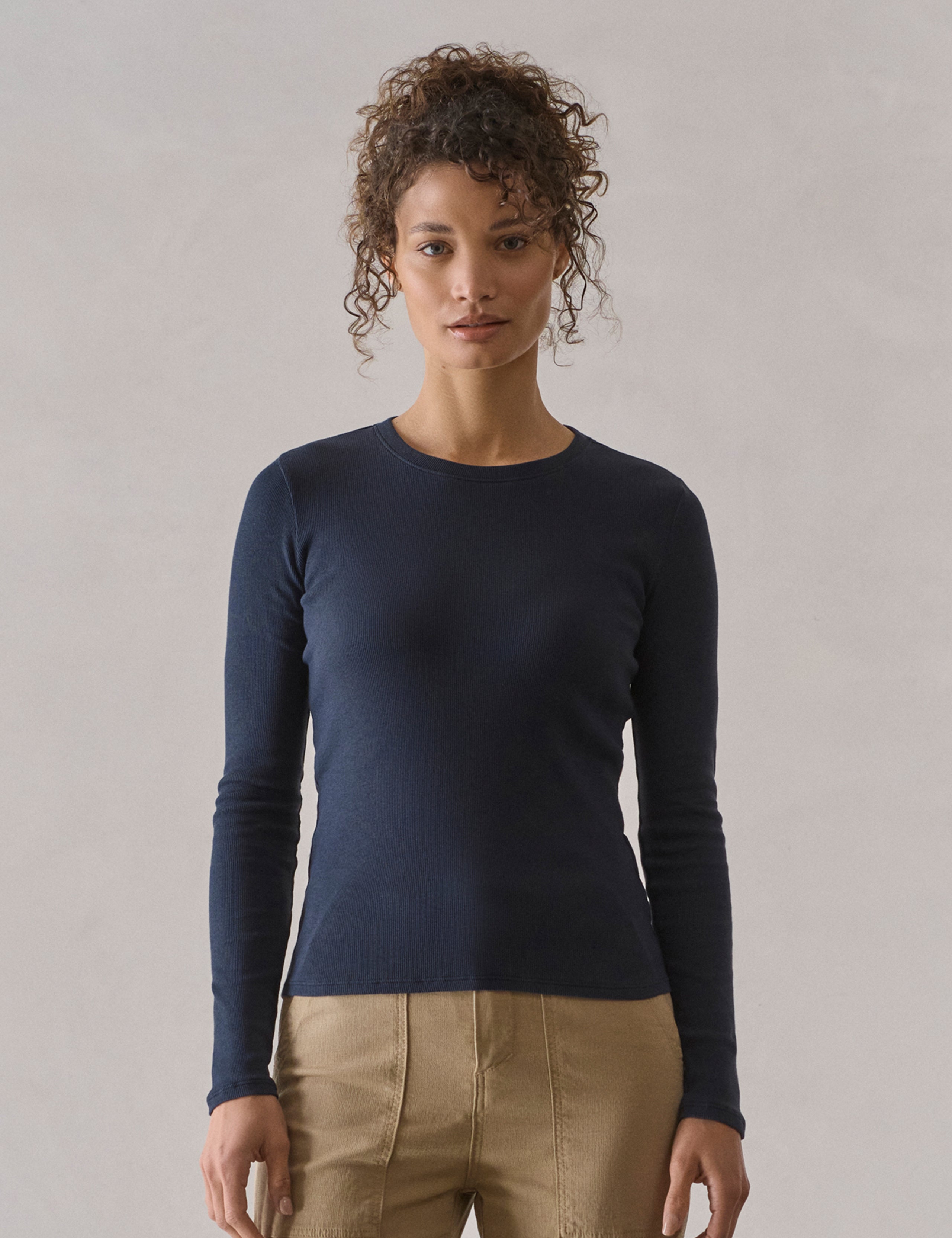 Front view of woman wearing Amara Long-Sleeve Crew in Total Eclipse dark blue from AETHER Apparel.