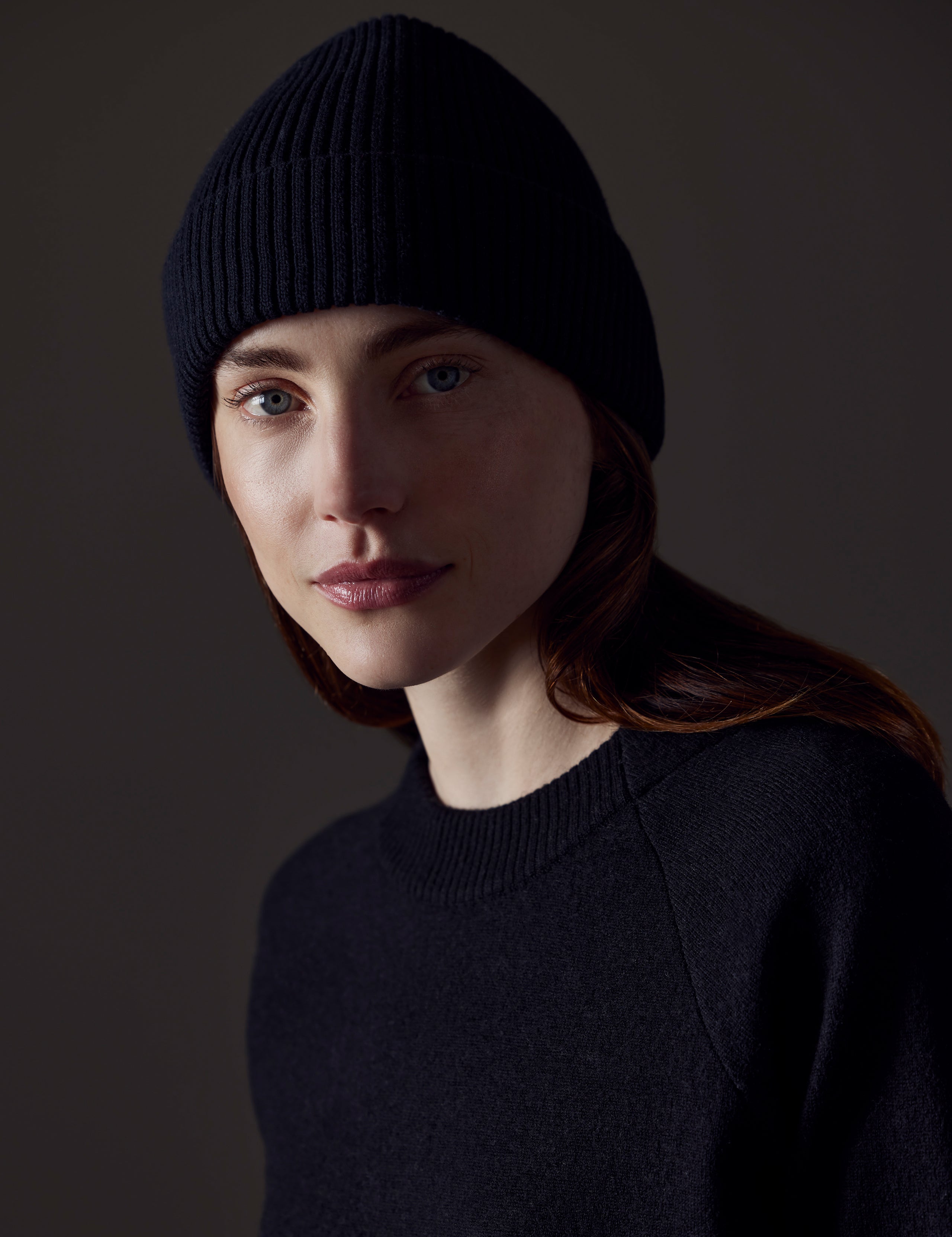Front angled view of woman wearing Chalet Cotton Beanie in Onyx Black from AETHER Apparel. 