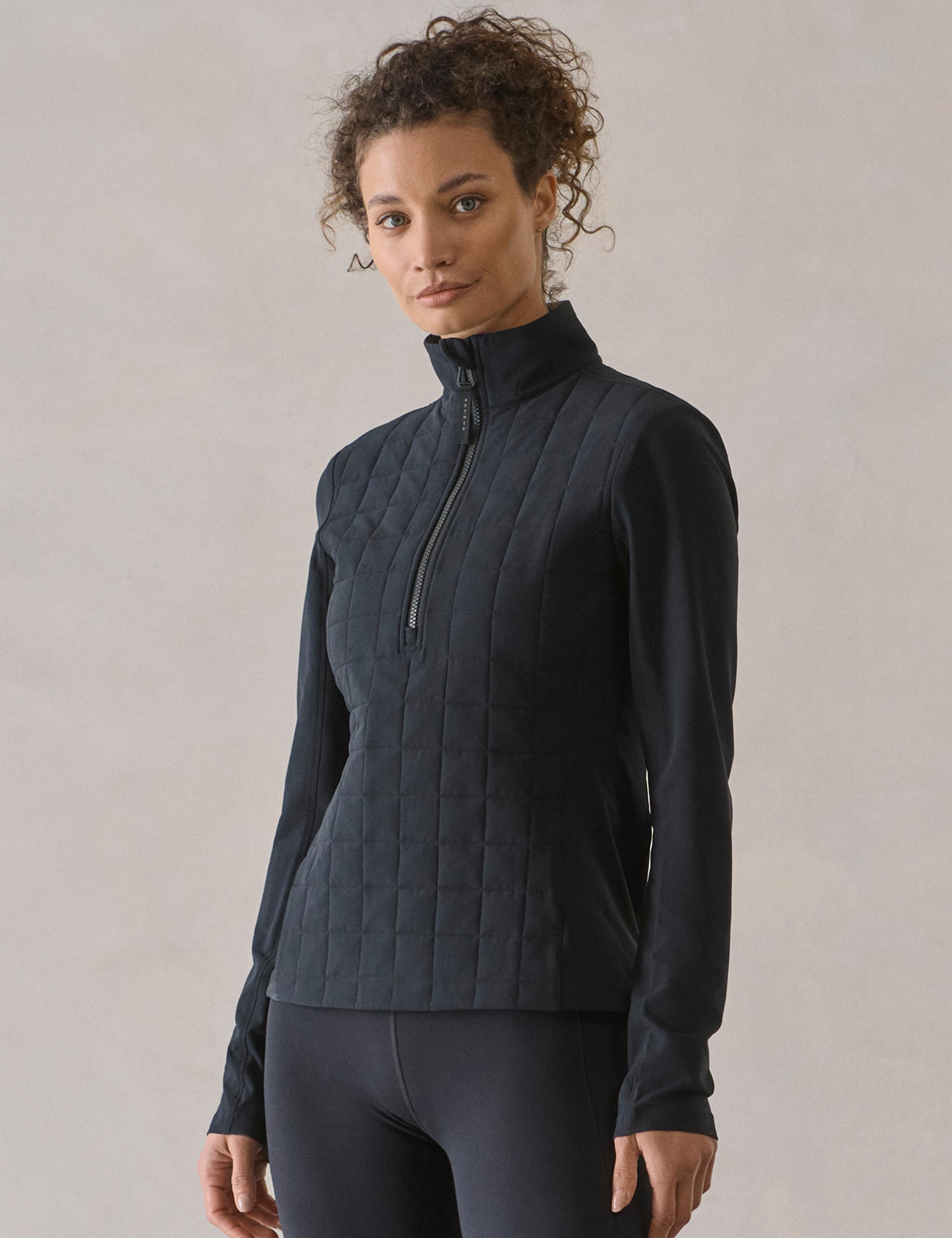 Woman in studio wearing the Wren Insulated Half-Zip in Onyx Black