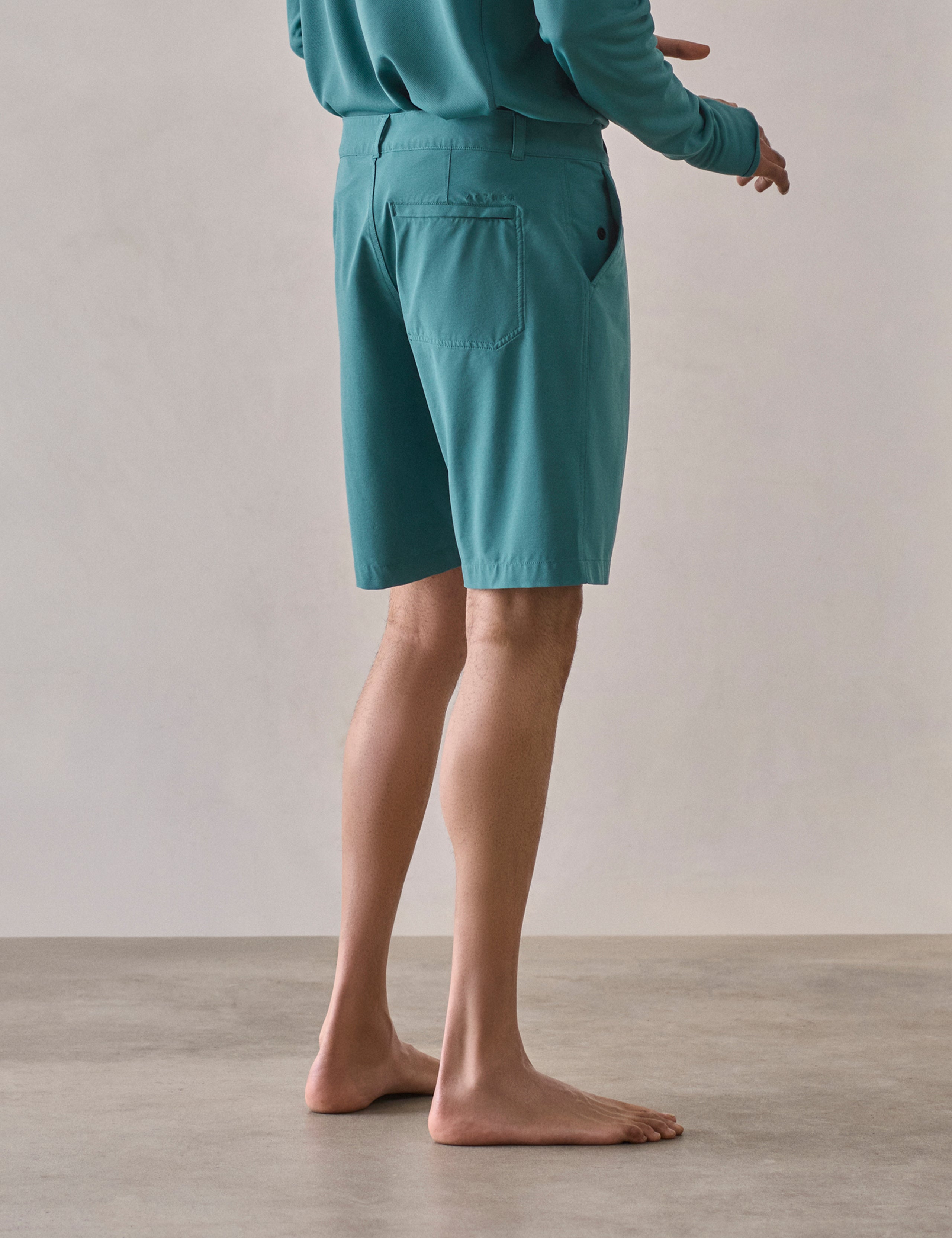 Rear 3/4 lower-body view of man wearing Catalina Submersible Short in Aqua Blue from AETHER Apparel.