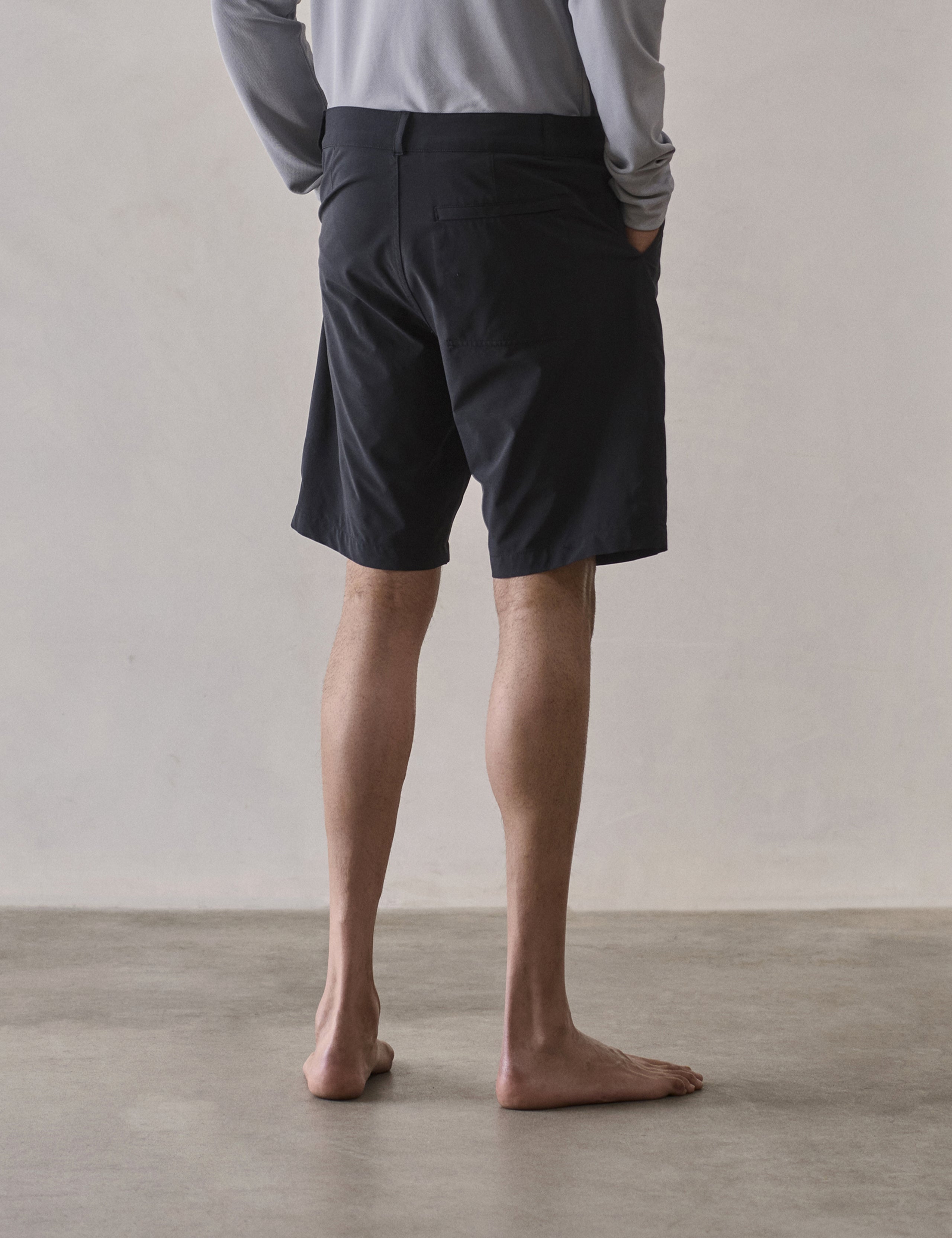 Rear 3/4 lower-body view of man wearing Catalina Submersible Short in Onyx Black from AETHER Apparel.