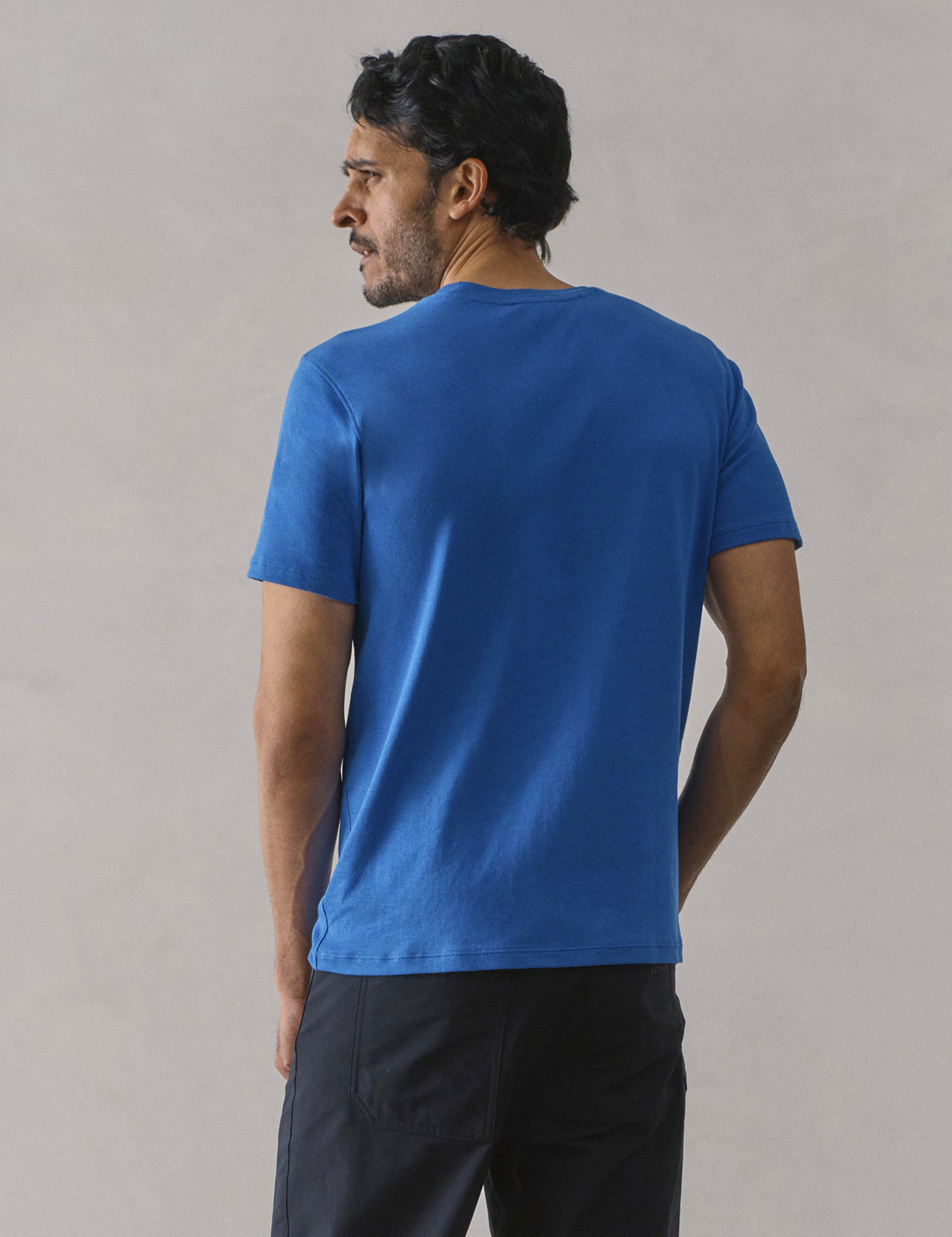 Rear view of man wearing Emery Pima Crew Tee in Summit Blue from AETHER Apparel.