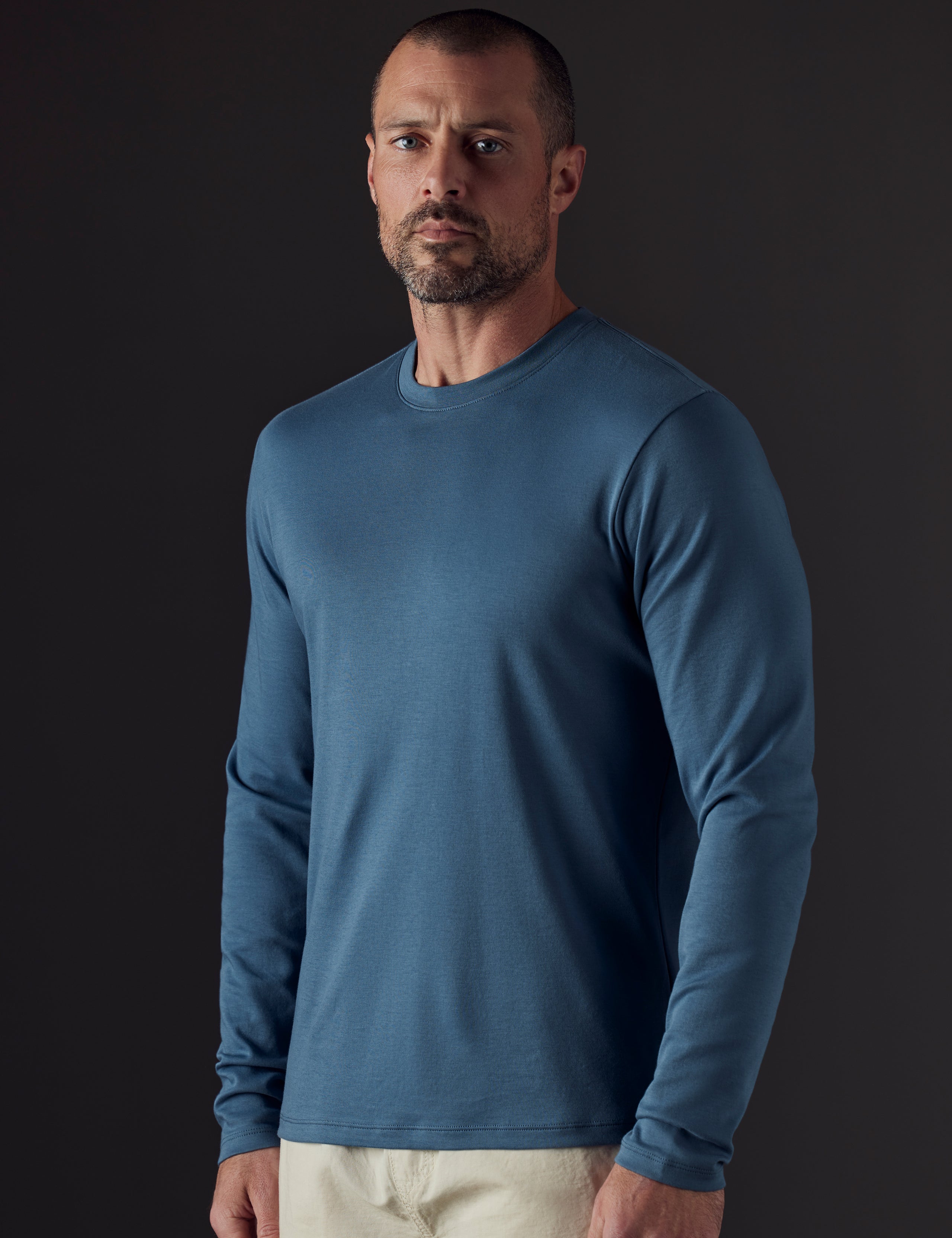 Front body view of man wearing Emery Pima Long-Sleeve Tee in Coastal Blue from AETHER Apparel.