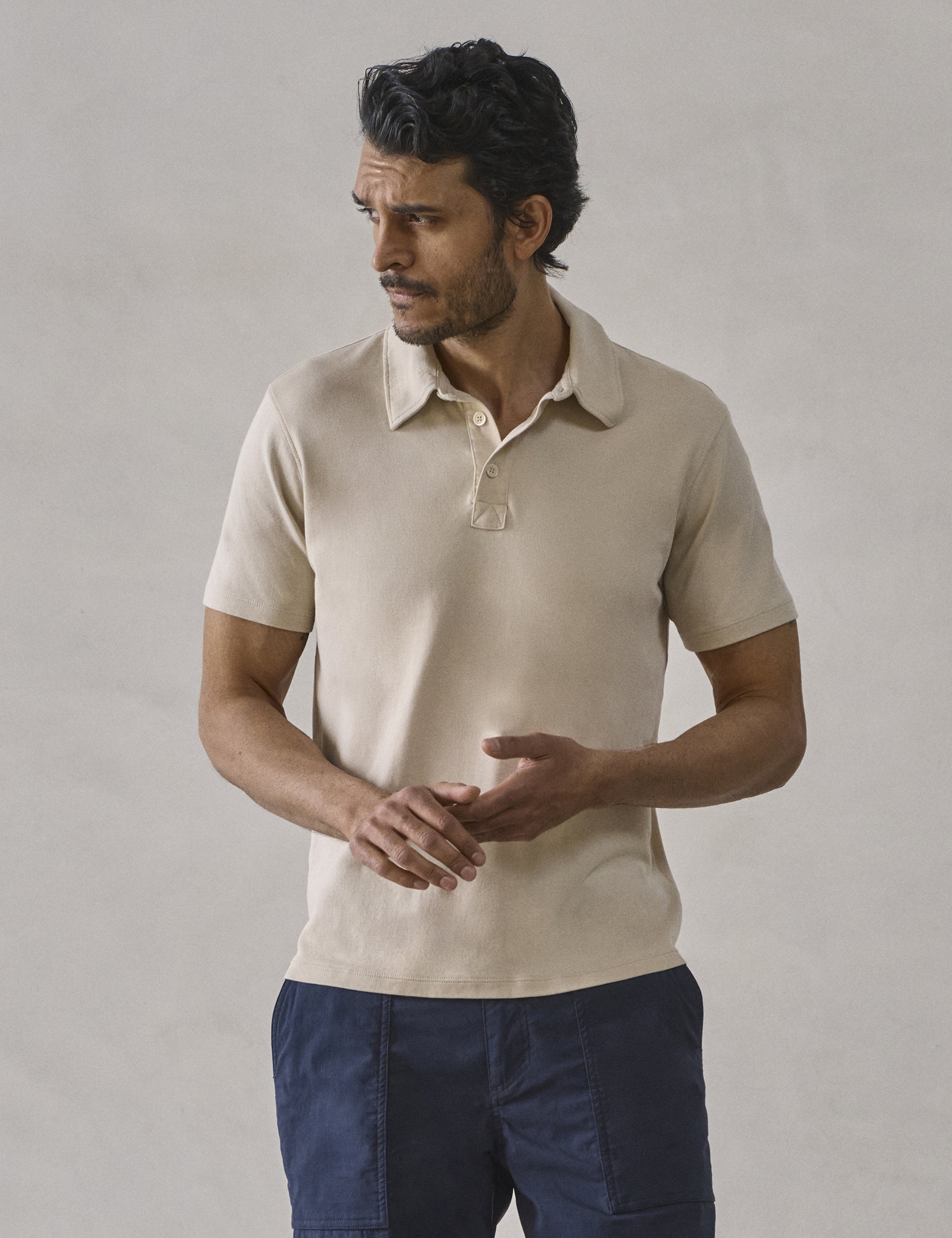 Front view of man wearing Emery Pima Polo in Bone white from AETHER Apparel.