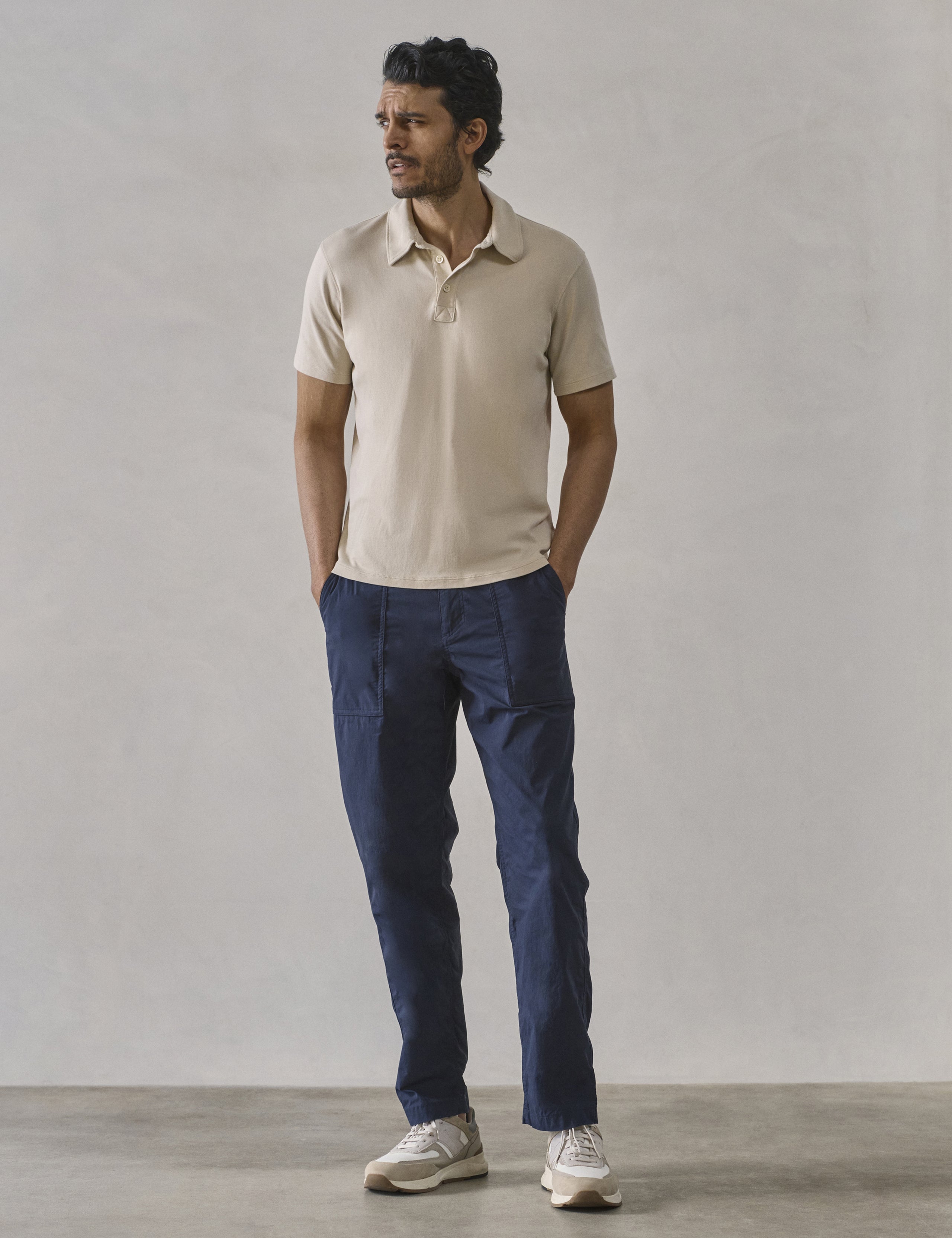 Front full-body view of man wearing Emery Pima Polo in Bone white from AETHER Apparel.