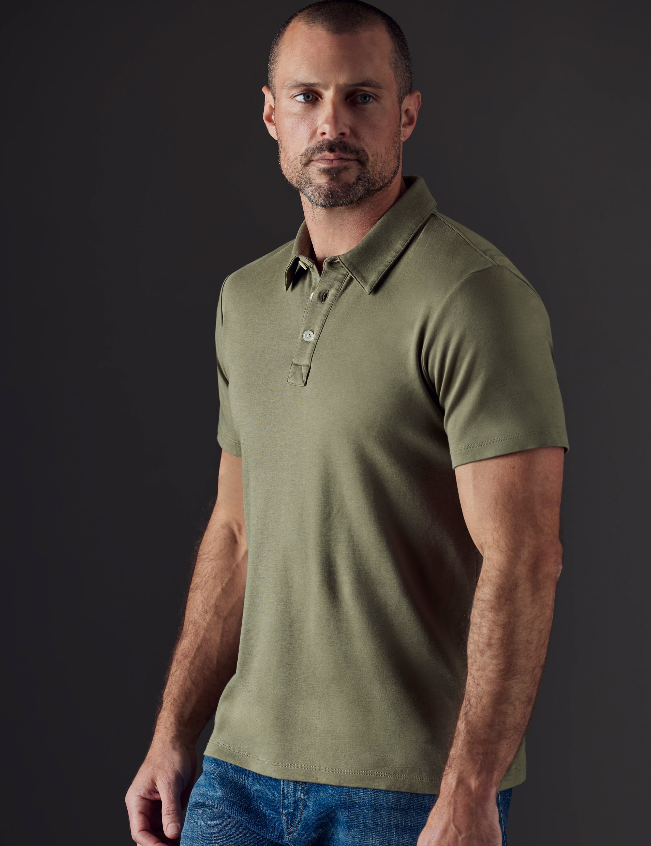 Front 3/4 body view of man wearing Emery Pima Polo in Fern Green from AETHER Apparel.