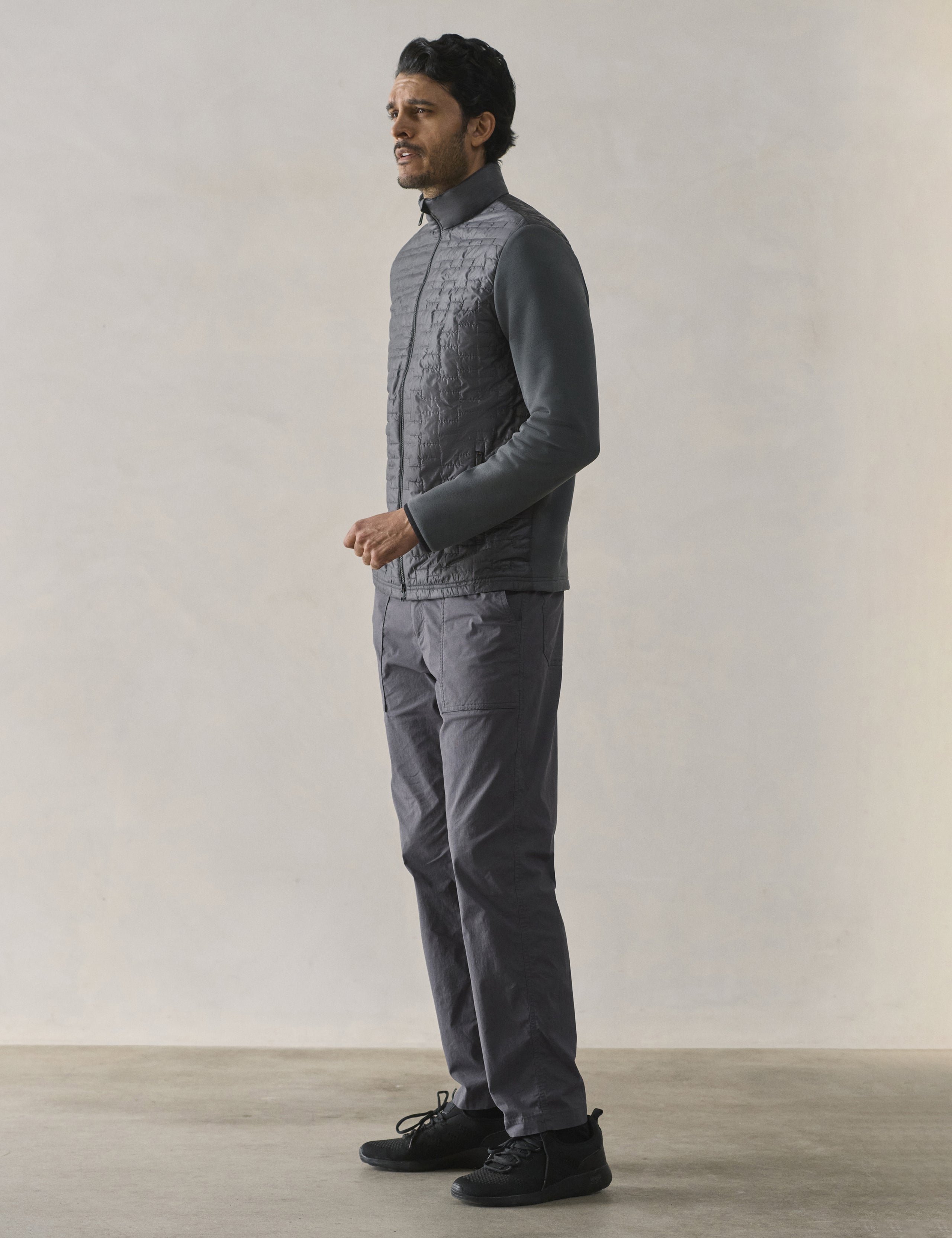 Front 3/4 full-body view of man wearing Hybrid Tech Full-Zip in Graphite from AETHER Apparel.