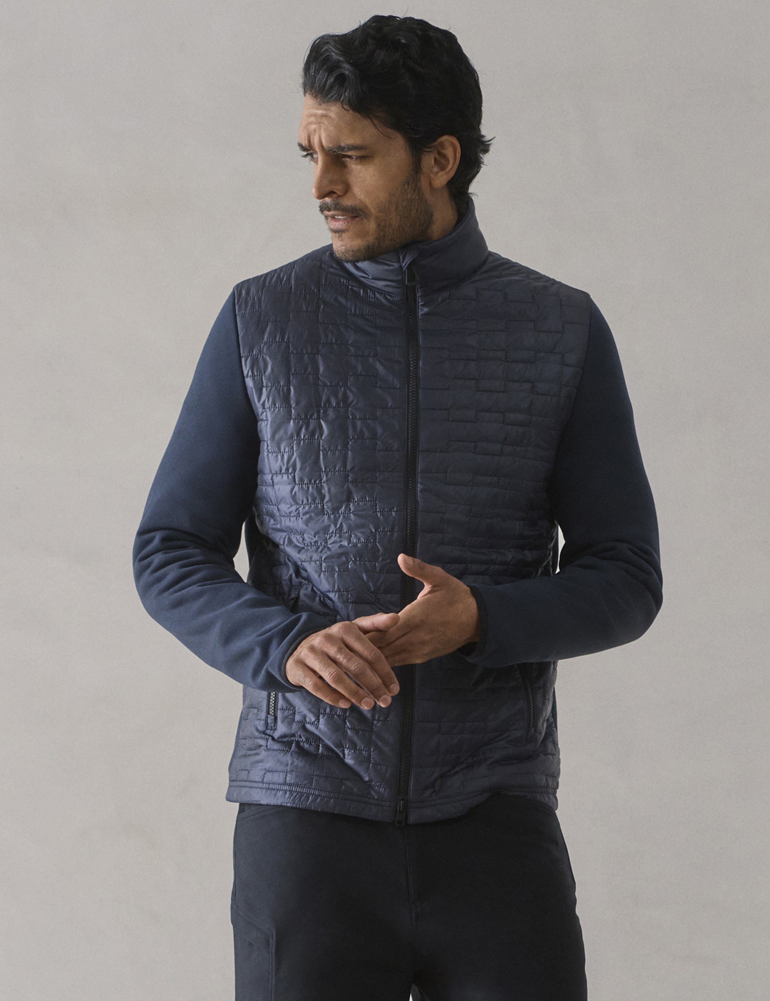 Front upper body view of man wearing Hybrid Tech Full-Zip in Total Eclipse dark blue from AETHER Apparel.