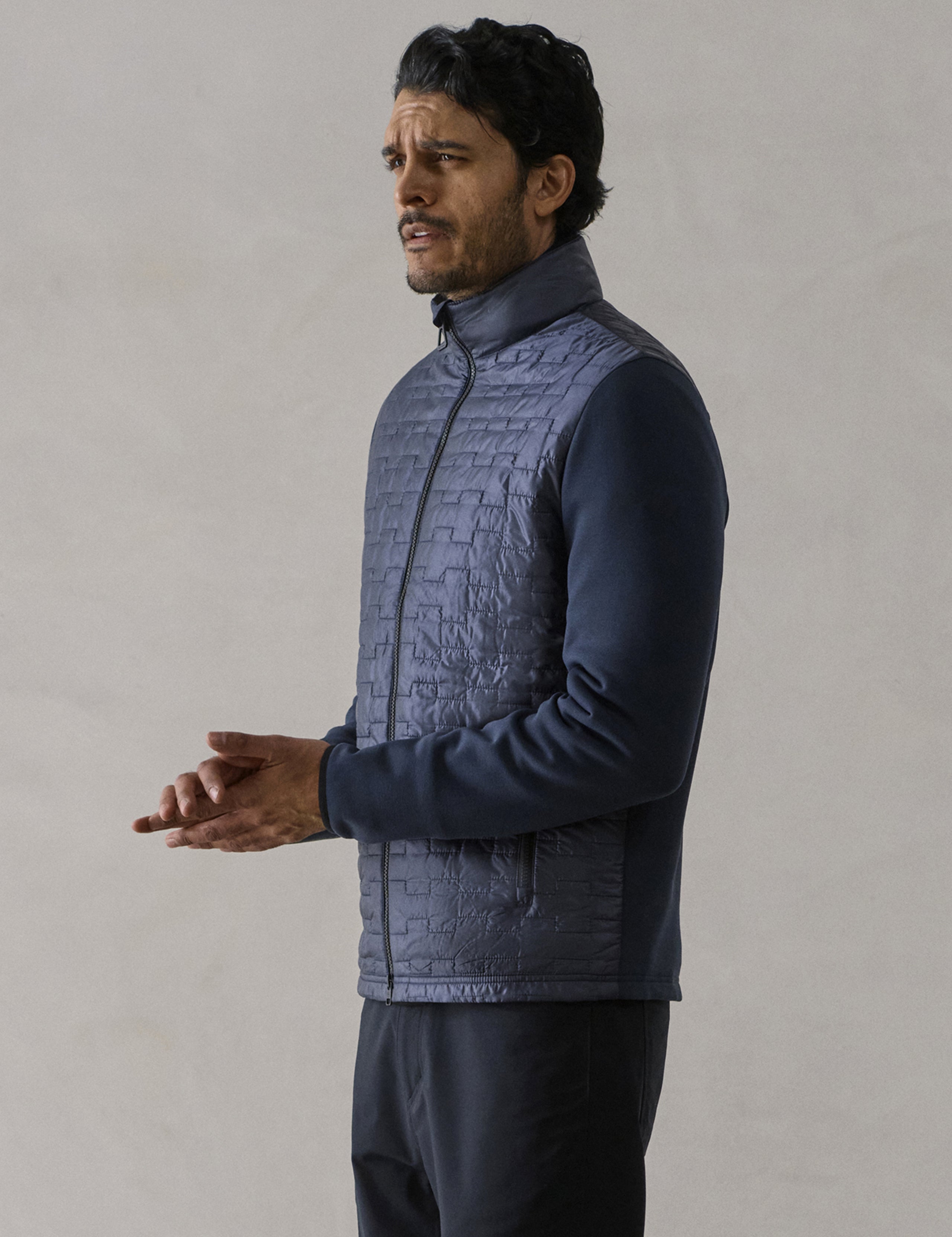 Front 3/4 body view of man wearing Hybrid Tech Full-Zip in Total Eclipse dark blue from AETHER Apparel.