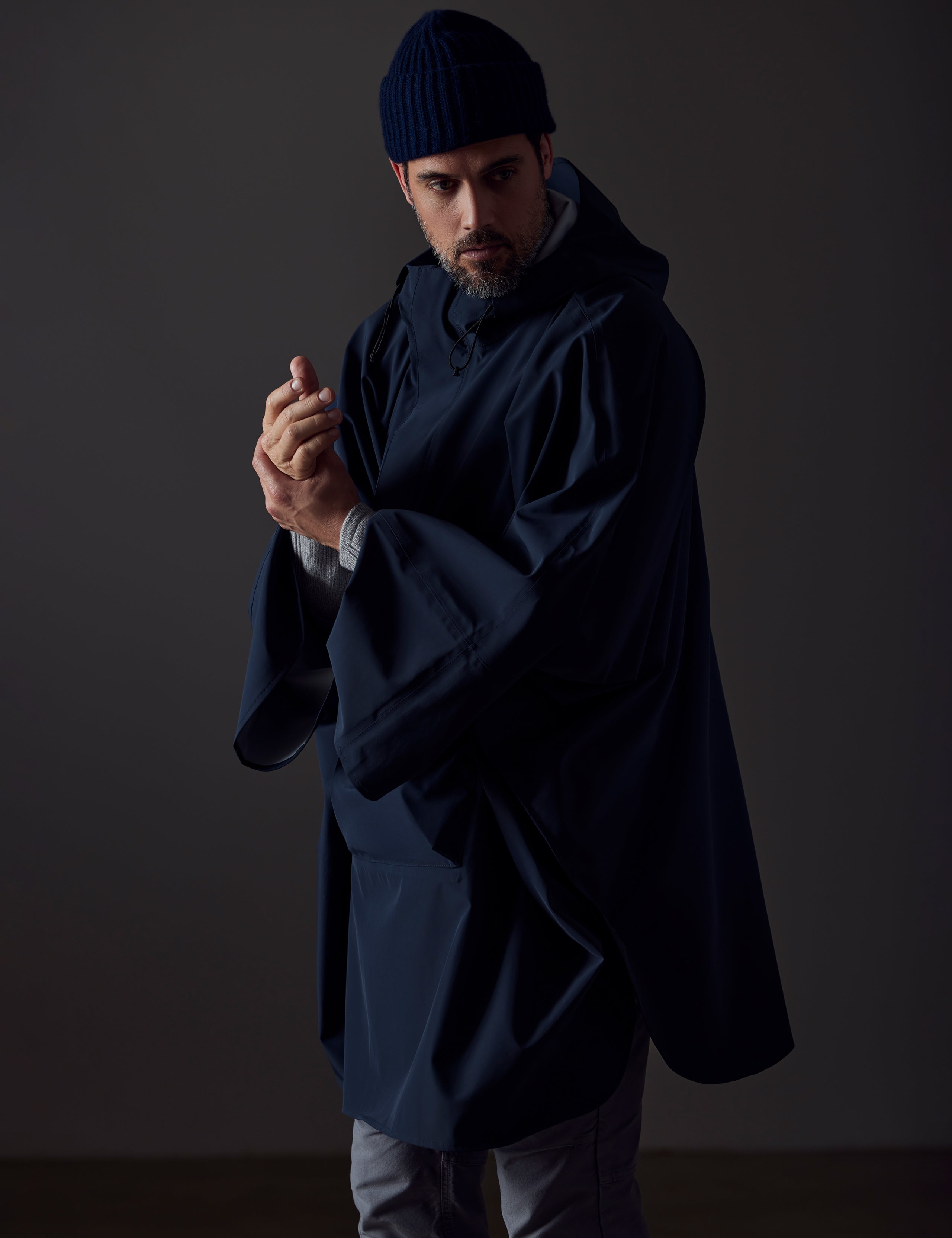 Front angled view of man wearing blue Line Poncho from AETHER Apparel.