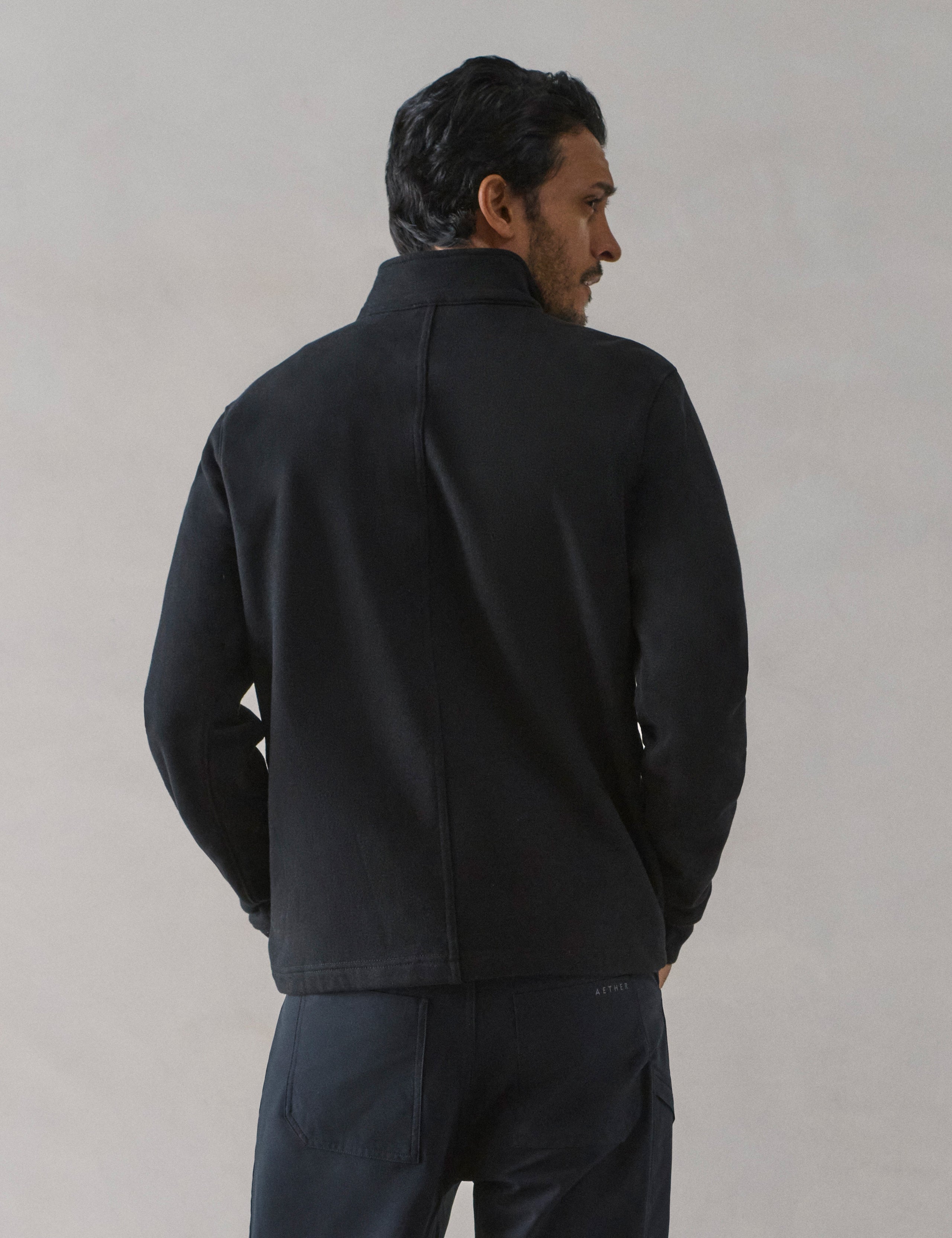Rear view of man wearing Monte Half-Zip Sweatshirt in Onyx Black from AETHER Apparel.