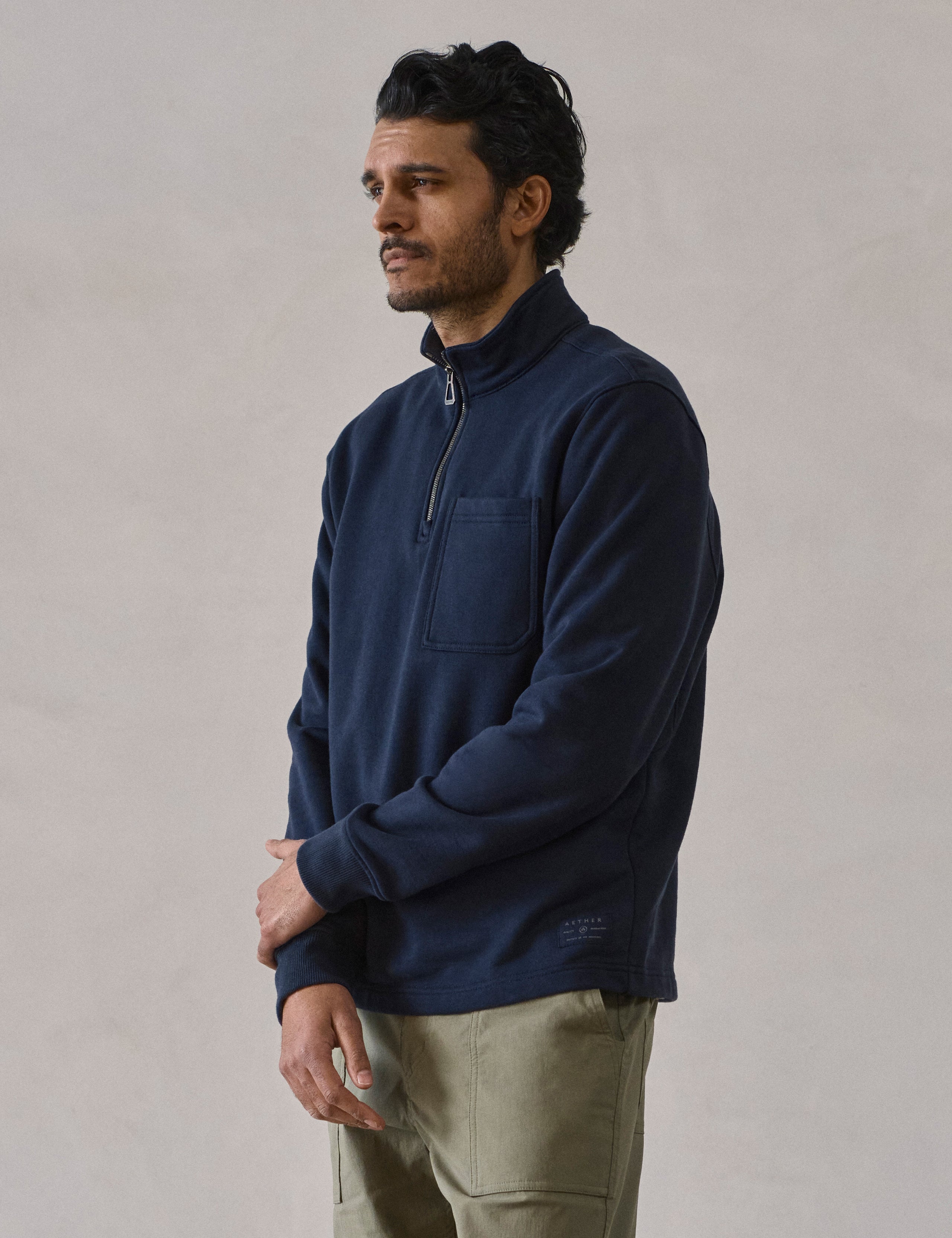 Front 3/4 body view of man wearing Monte Half-Zip Sweatshirt in Total Eclipse dark blue from AETHER Apparel.