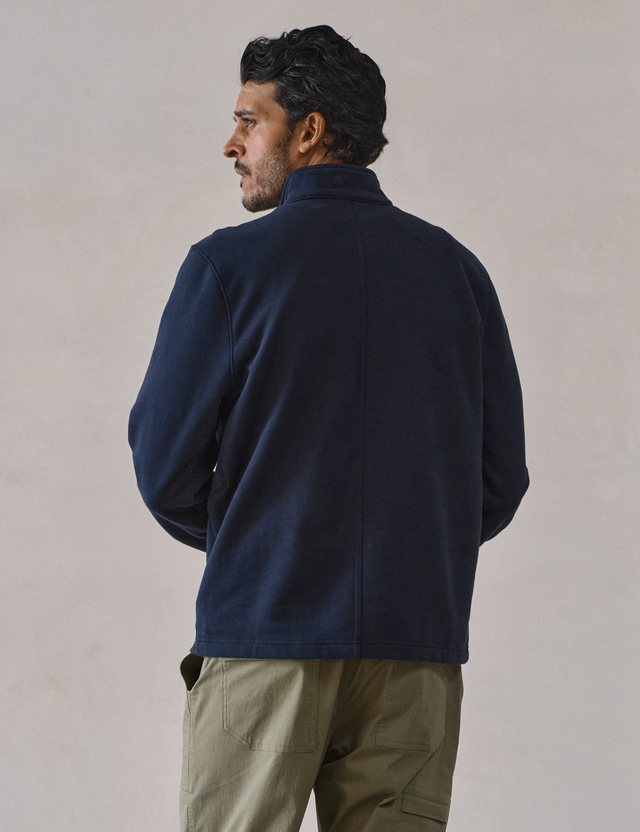 Rear view of man wearing Monte Half-Zip Sweatshirt in Total Eclipse dark blue from AETHER Apparel.