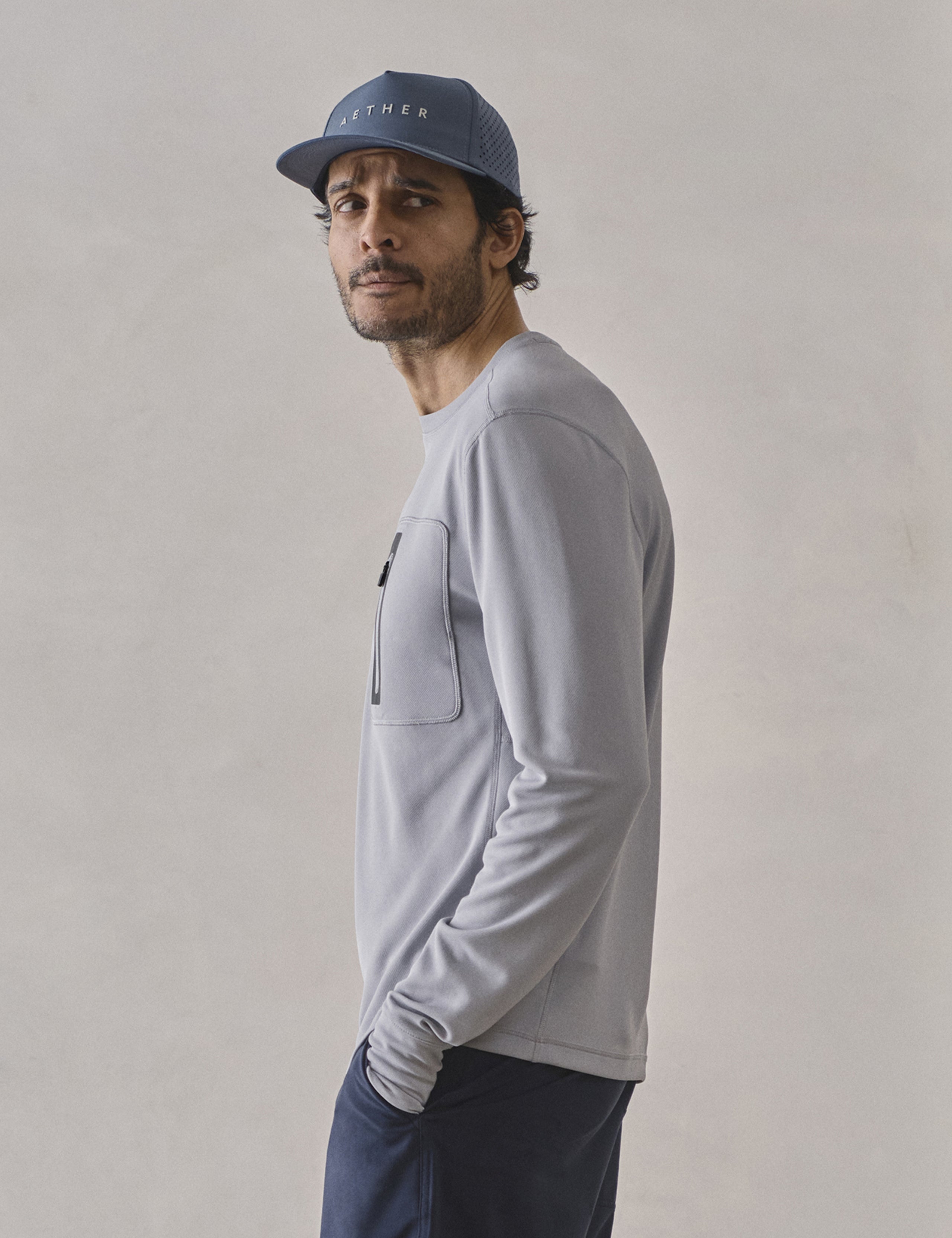 Side profile upper-body view of man wearing Pacific Crewneck Sun Shirt in Sky Grey from AETHER Apparel.