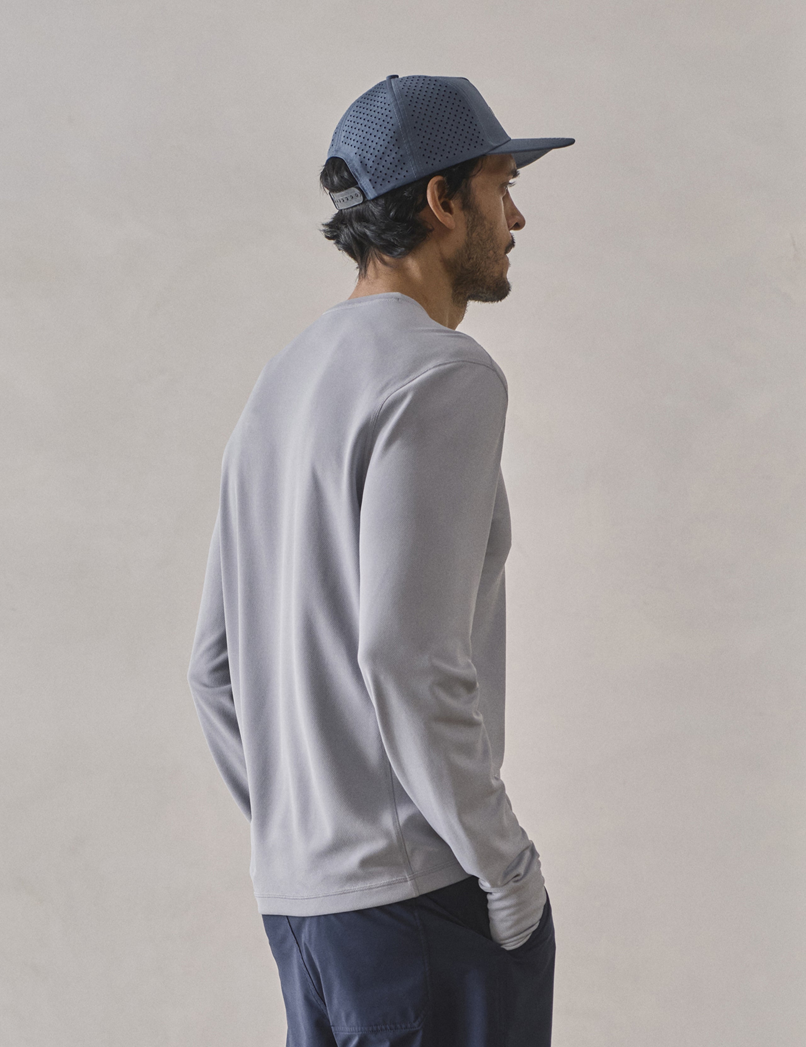 Rear 3/4 upper-body view of man wearing Pacific Crewneck Sun Shirt in Sky Grey from AETHER Apparel.