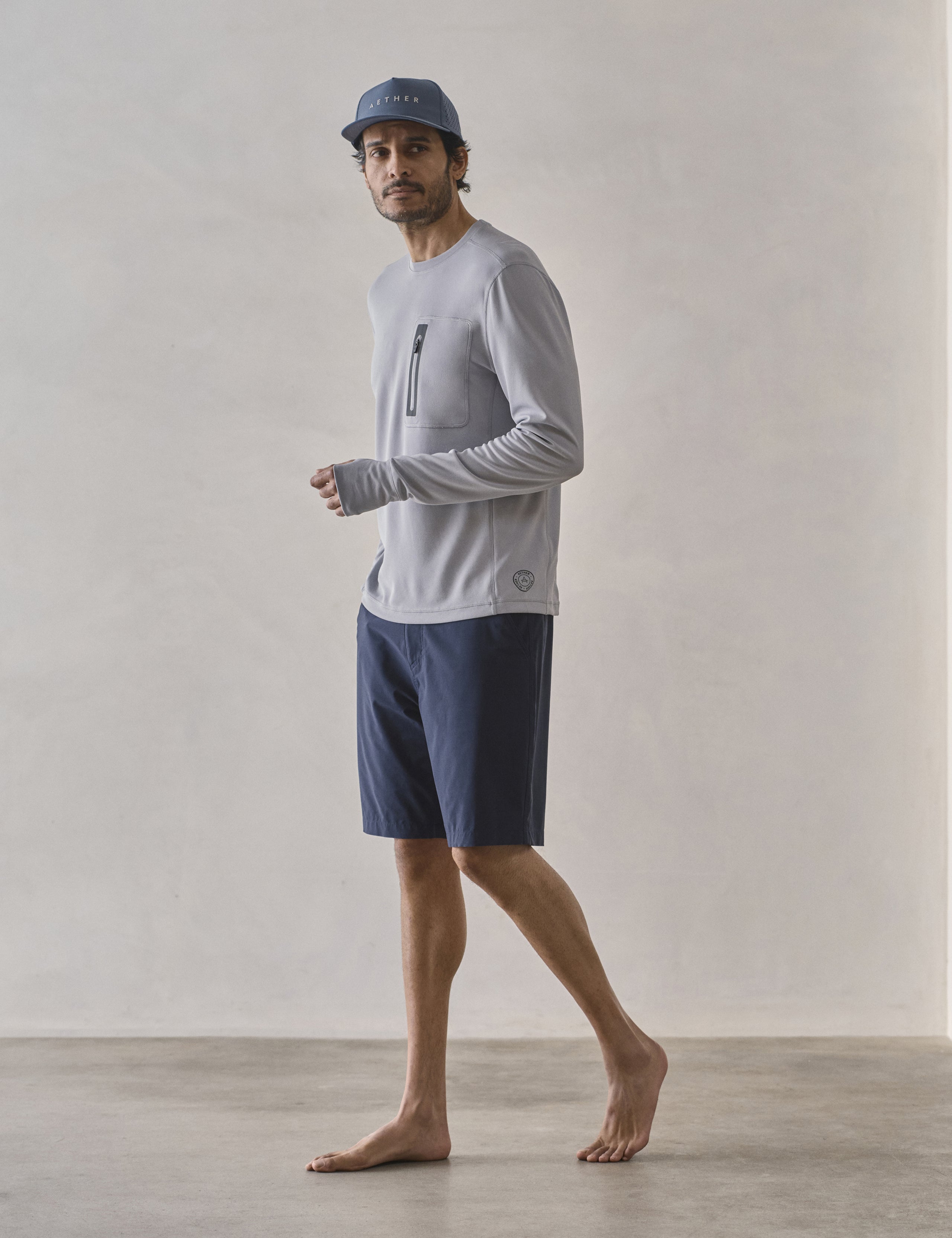 Front 3/4 full-body view of man wearing Pacific Crewneck Sun Shirt in Sky Grey from AETHER Apparel.