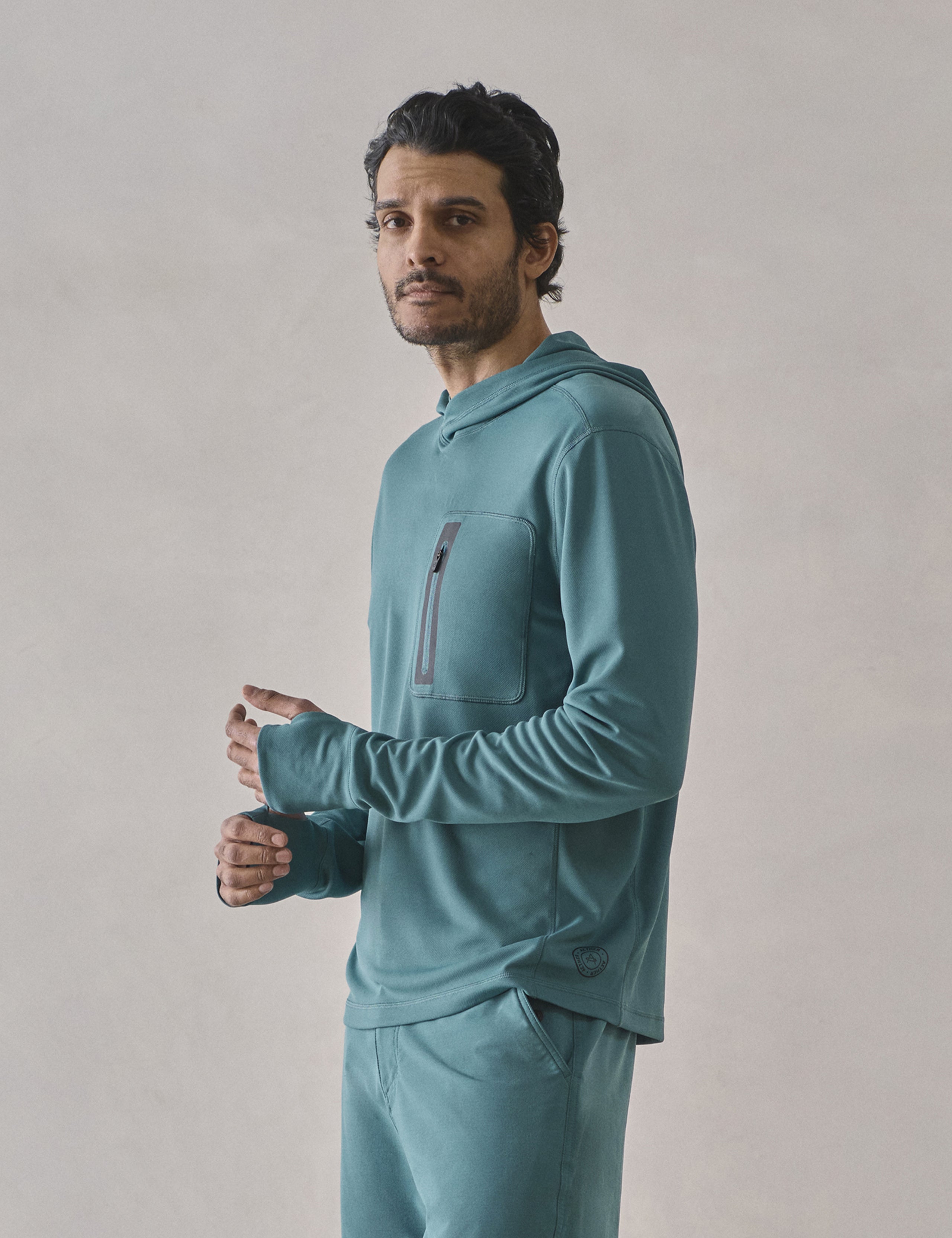 Front 3/4 upper-body view of man wearing Pacific Hooded Sun Shirt in Aqua Blue from AETHER Apparel.