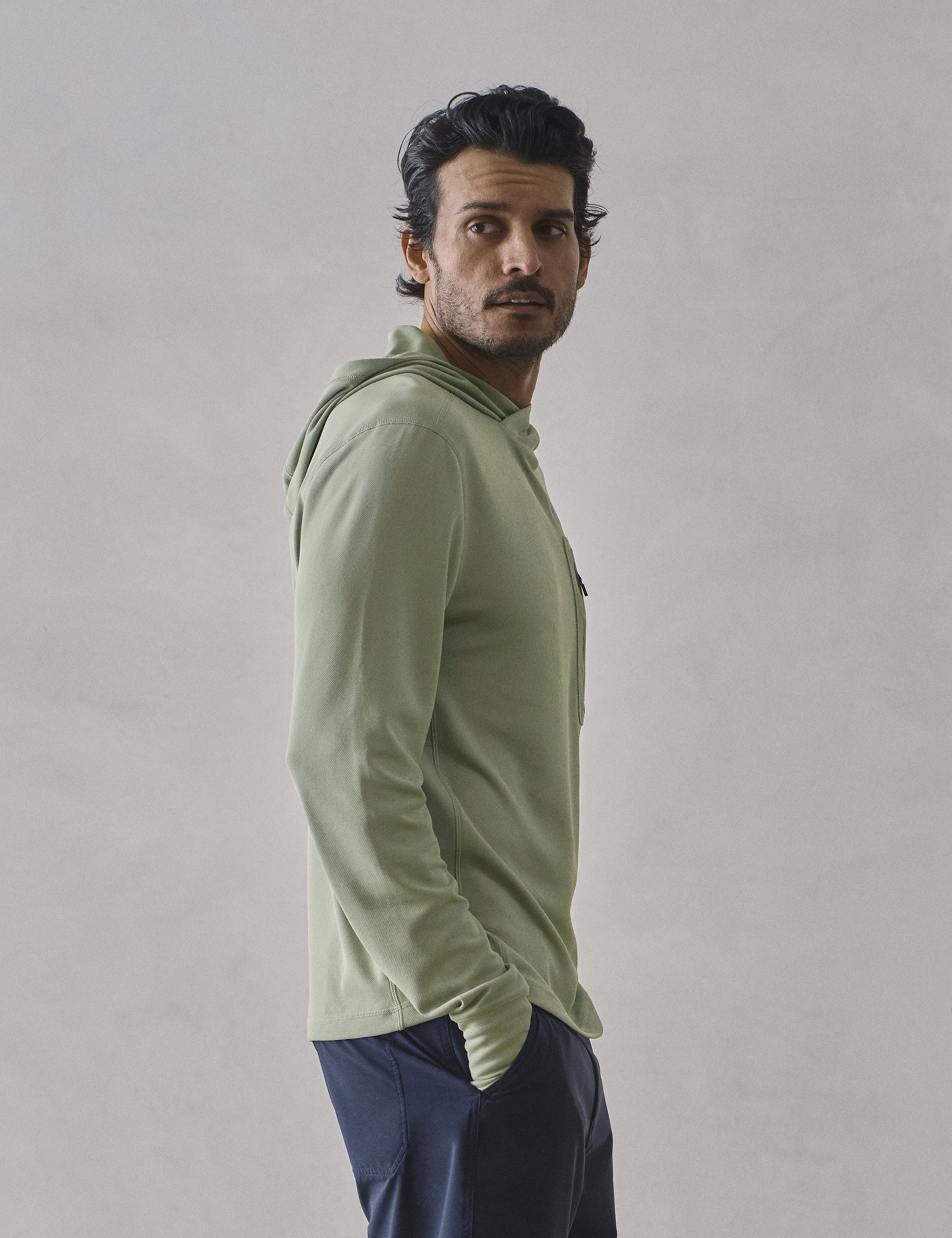 Side profile upper-body view of man wearing Pacific Hooded Sun Shirt in Aqua Blue from AETHER Apparel.