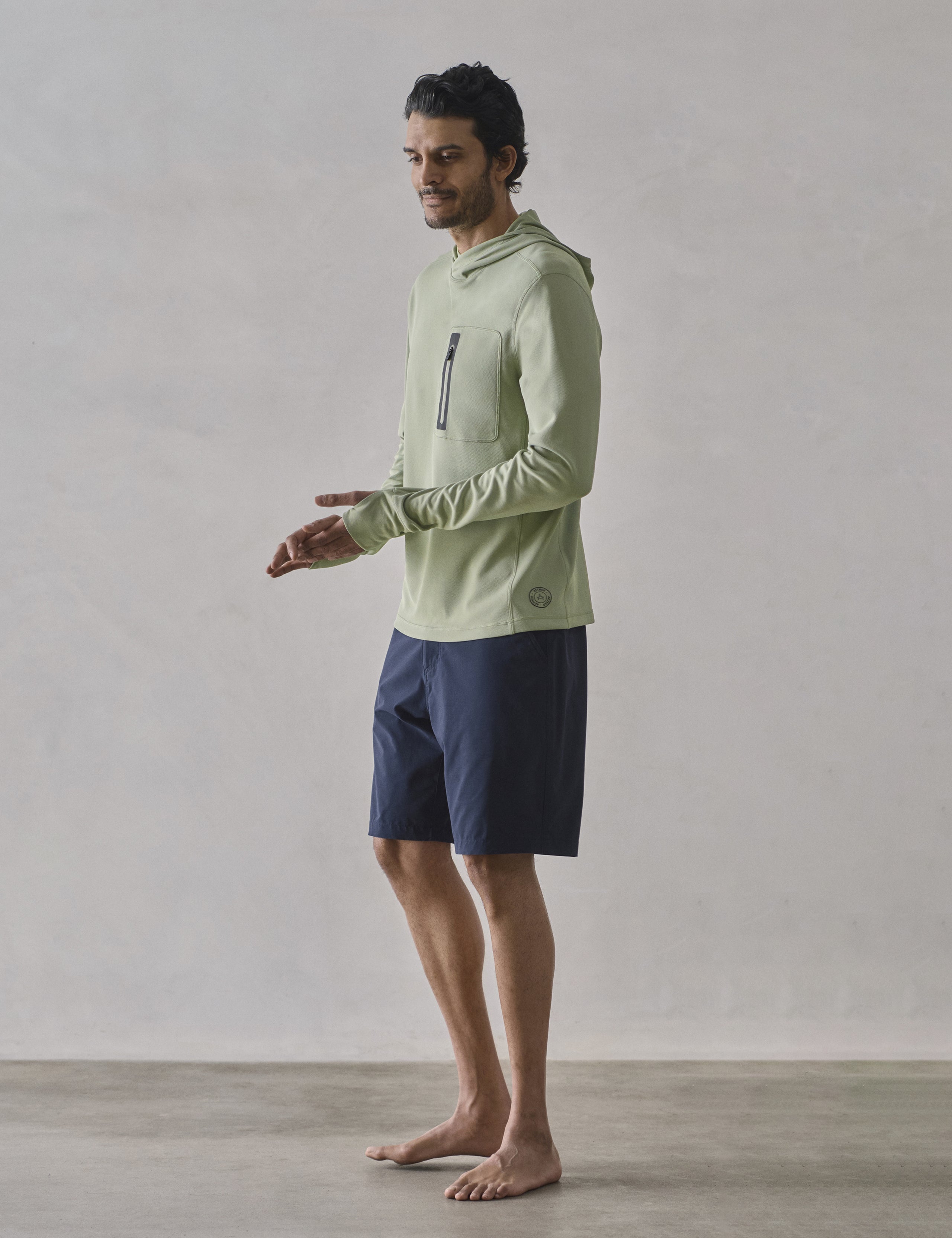 Front 3/4 full-body view of man wearing Pacific Hooded Sun Shirt in Aqua Blue from AETHER Apparel.