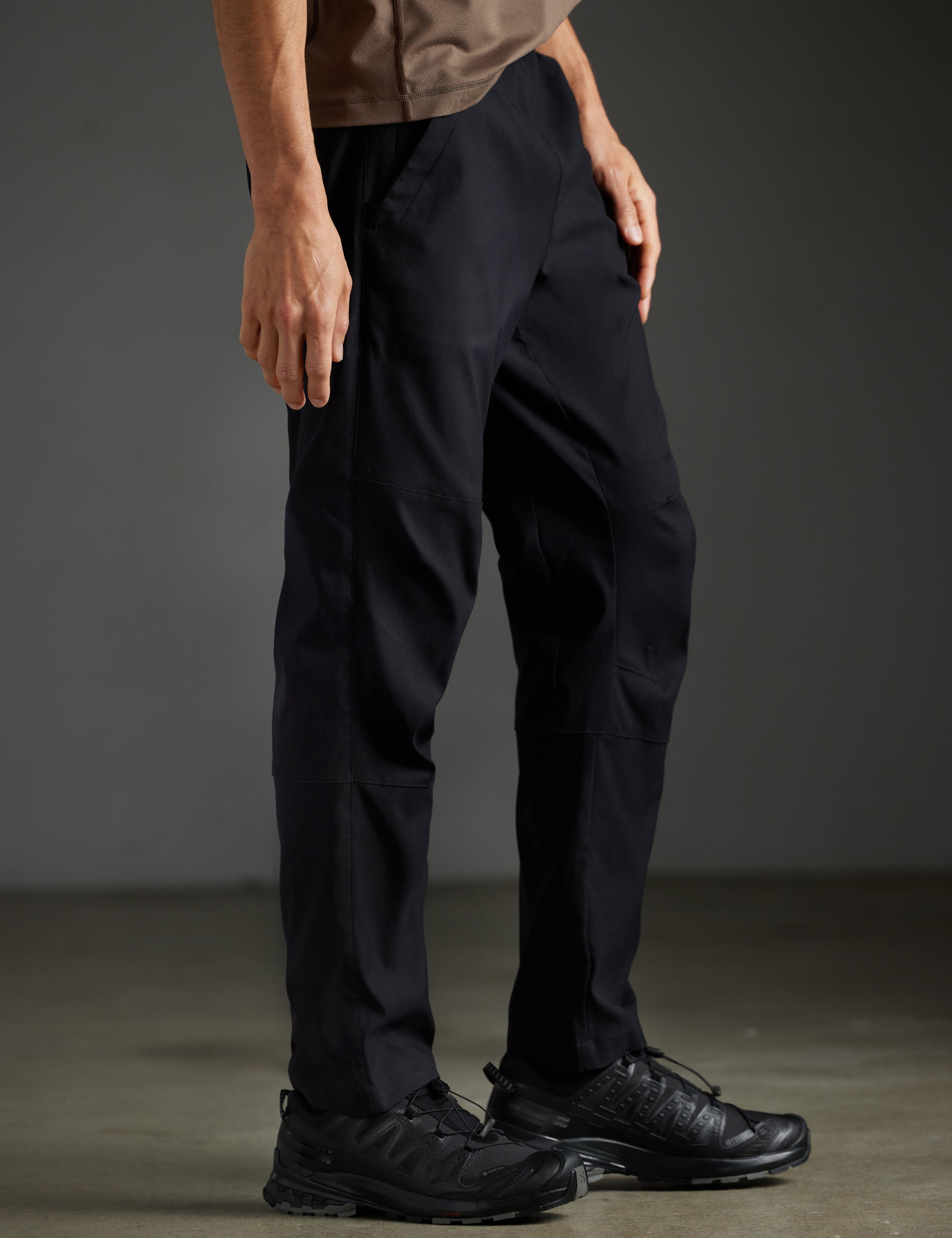 Side profile lower body view of man wearing Perth Pant in Onyx Black from AETHER Apparel.