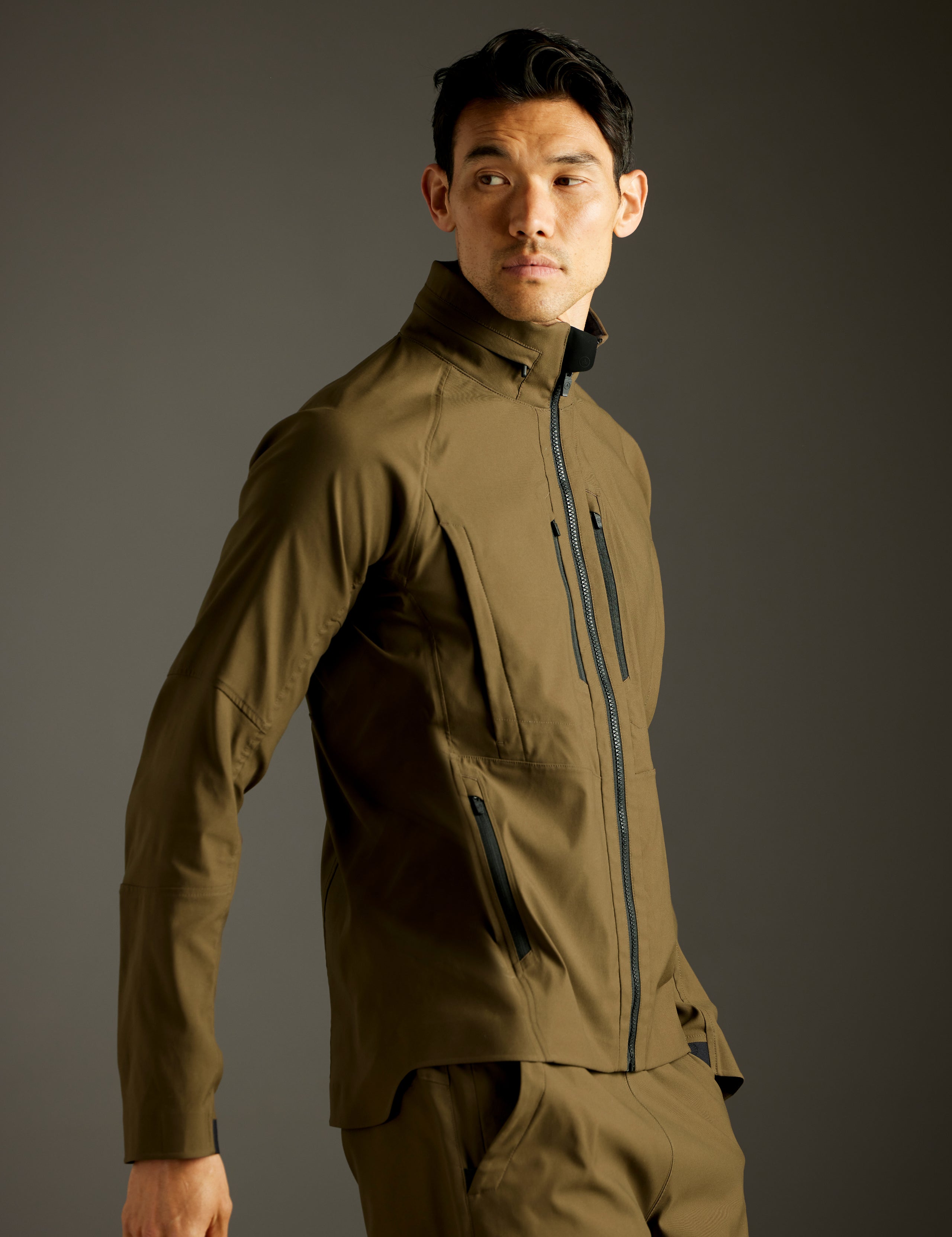 Side profile body view of man wearing Perth Vented Jacket in Cadet Green from AETHER Apparel.