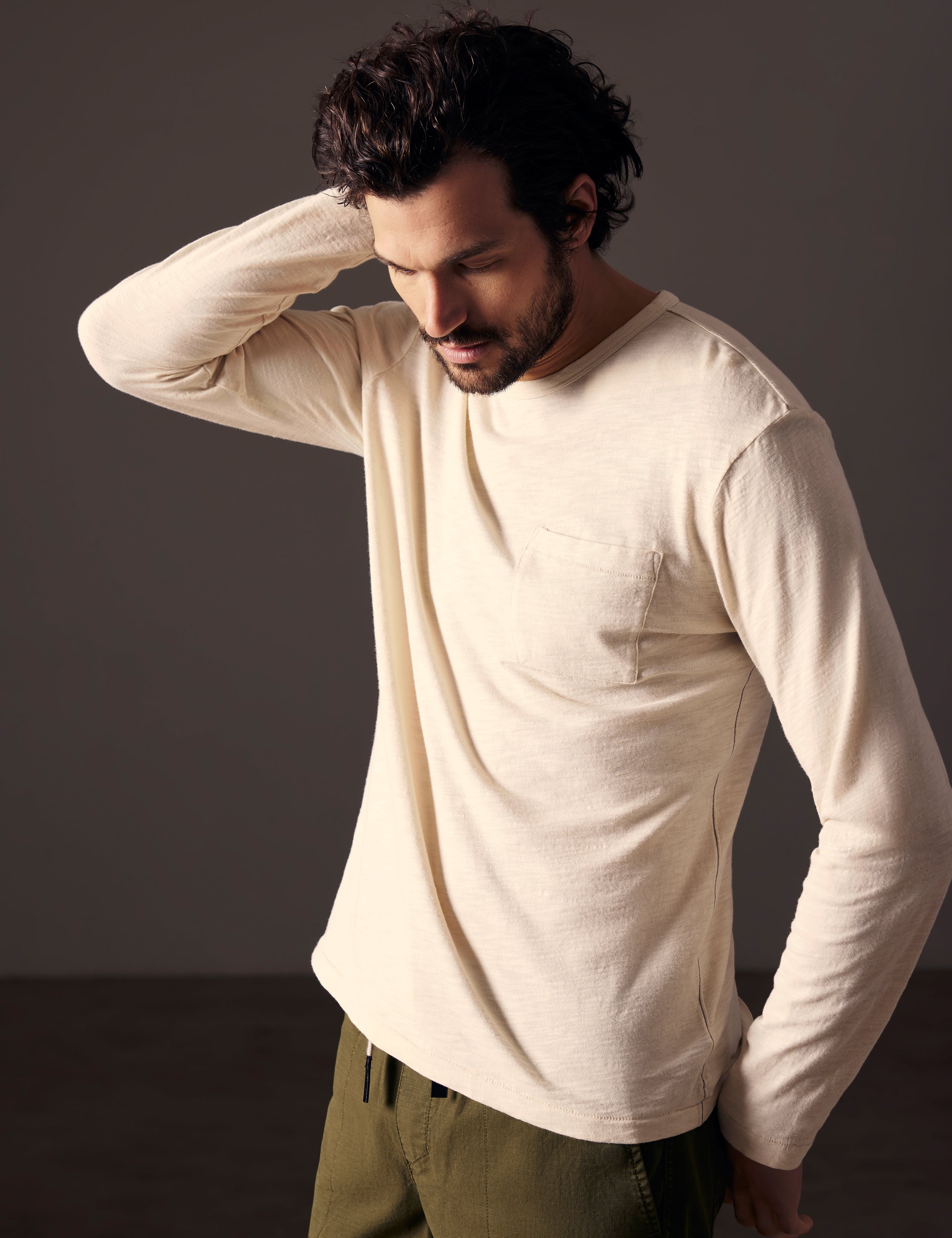 Front angled body view of man wearing Slub Long-Sleeve Tee in Bone white from AETHER Apparel.