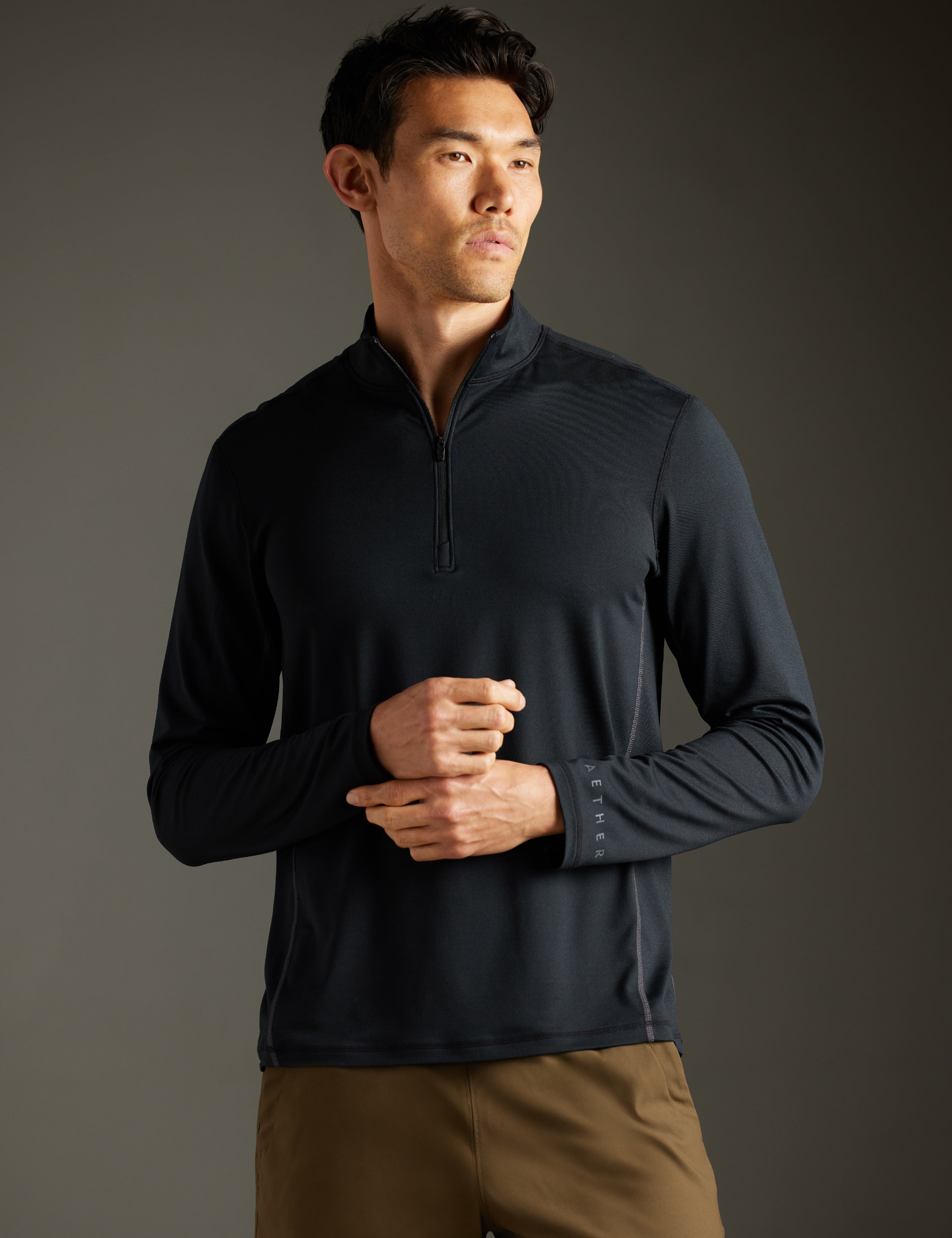 Front body view of man wearing Trek Articulated Half-Zip Tee in Onyx Black from AETHER Apparel.
