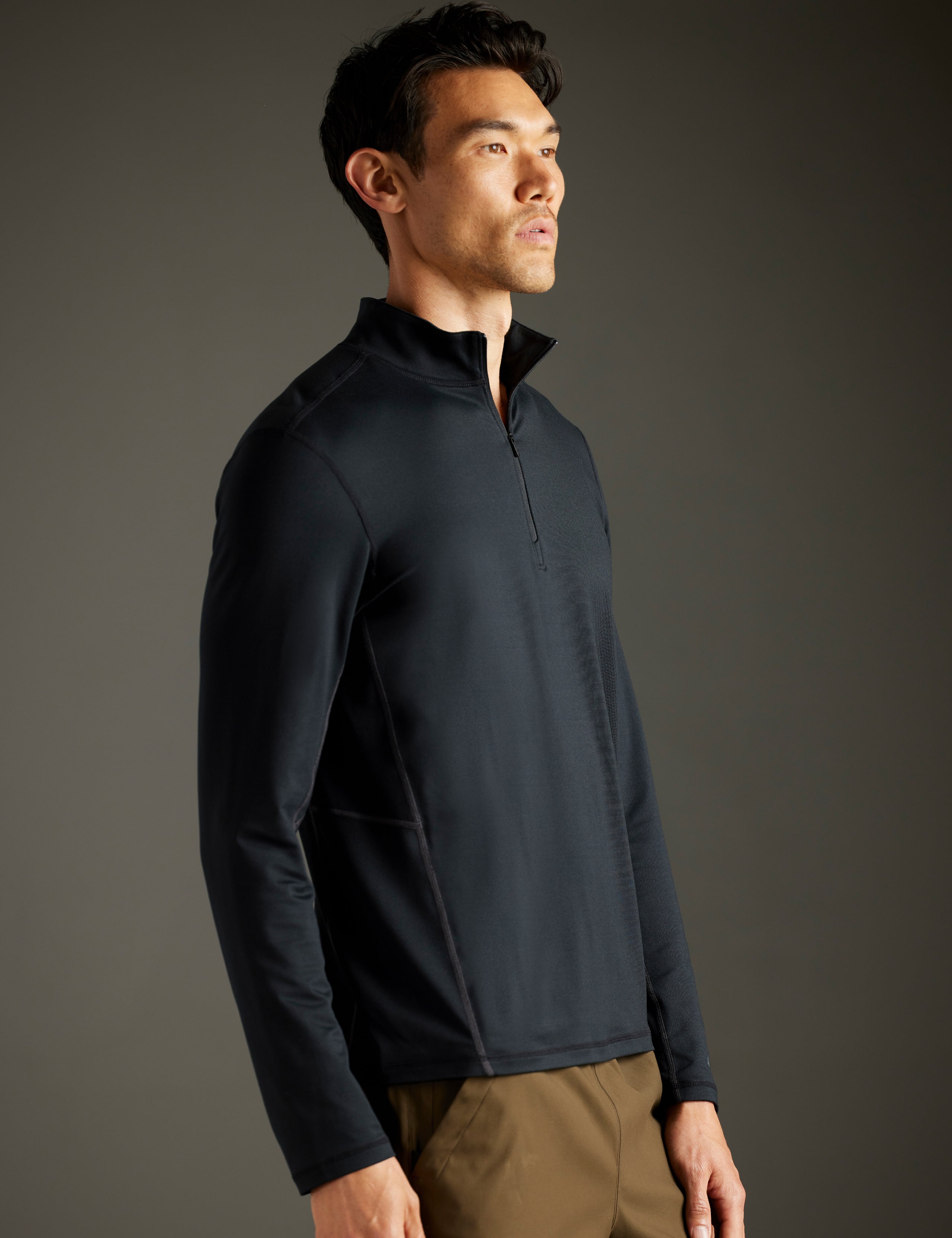 Front 3/4 body view of man wearing Trek Articulated Half-Zip Tee in Onyx Black from AETHER Apparel.