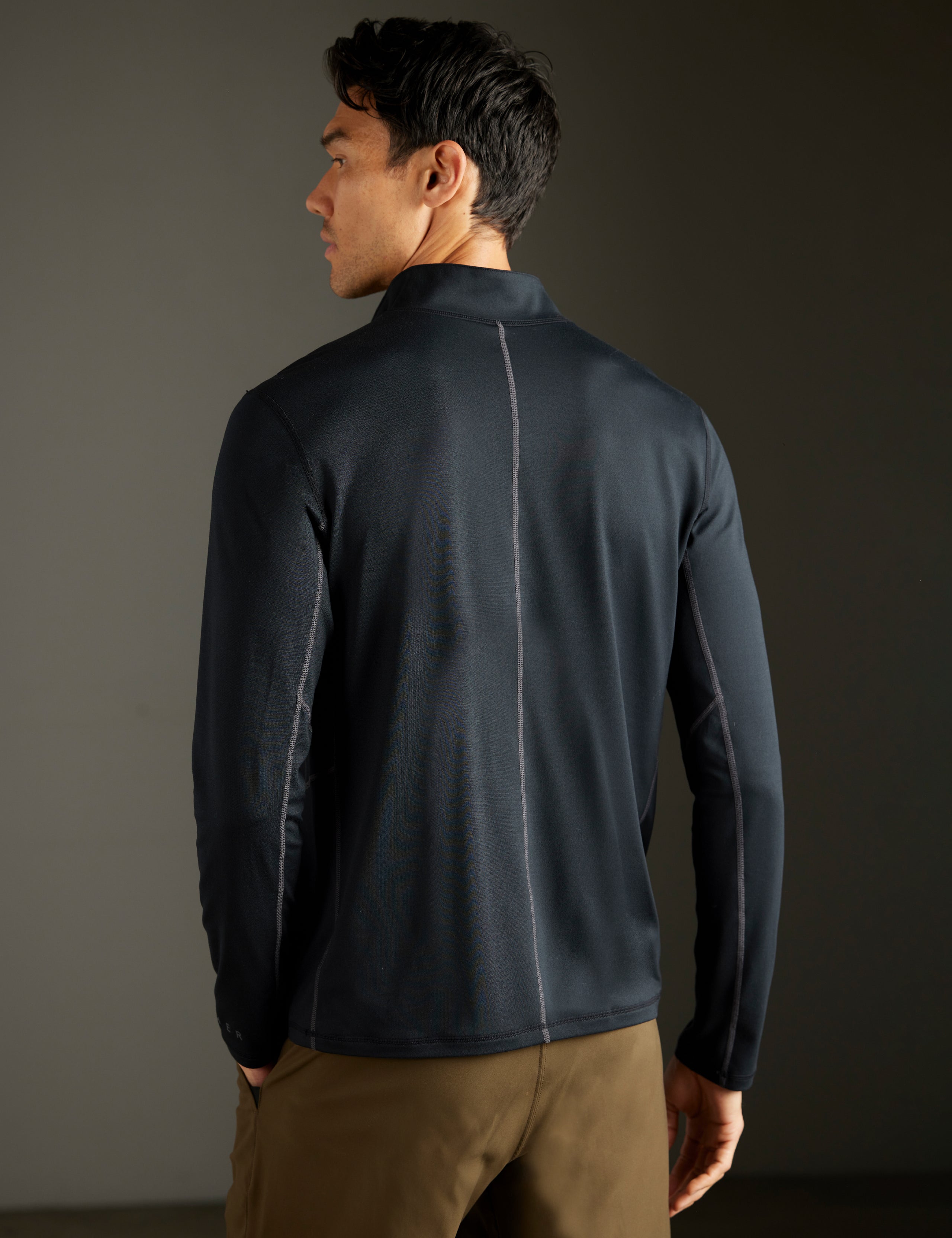 Rear body view of man wearing Trek Articulated Half-Zip Tee in Onyx Black from AETHER Apparel.