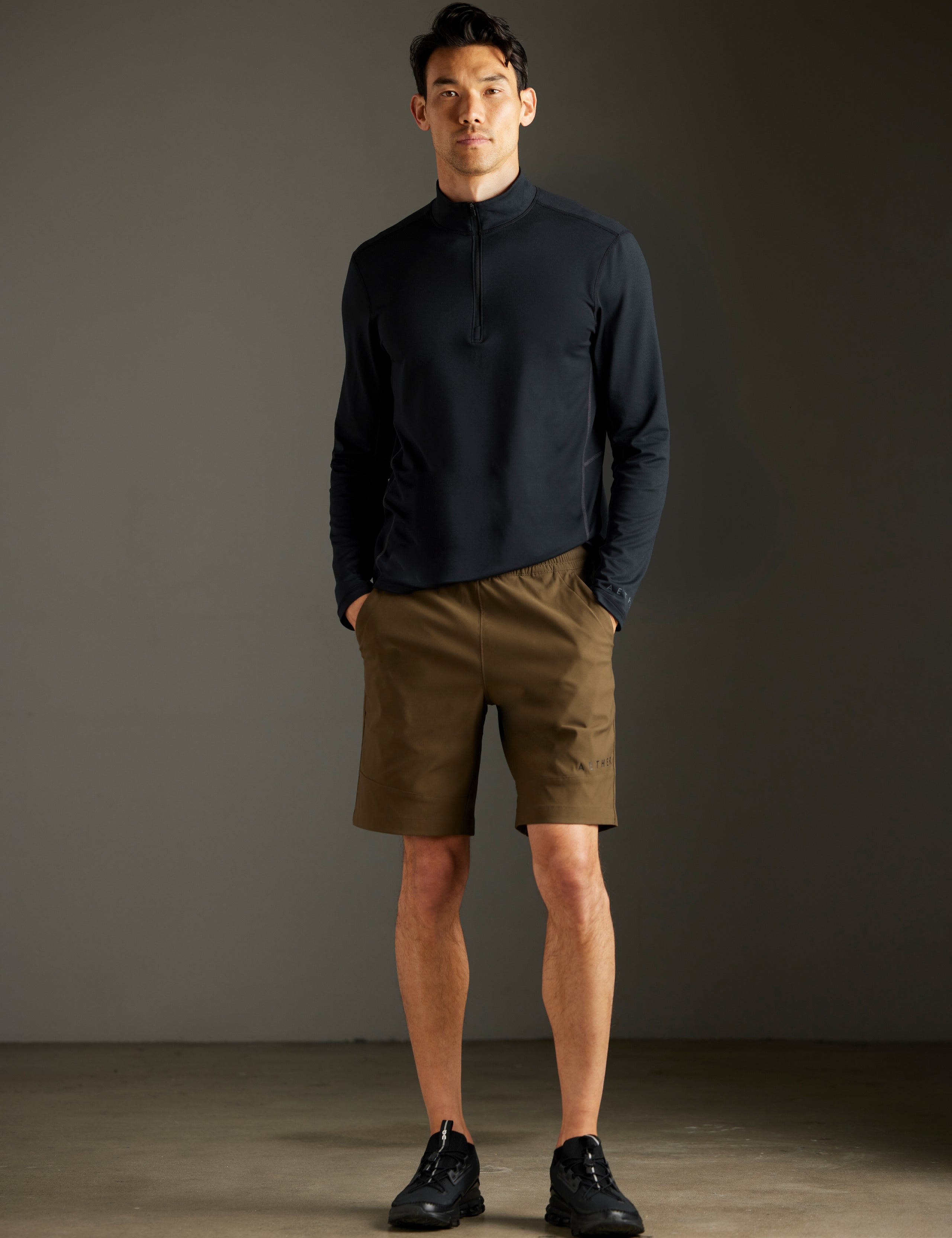 Front full-body view of man wearing Trek Articulated Half-Zip Tee in Onyx Black from AETHER Apparel.