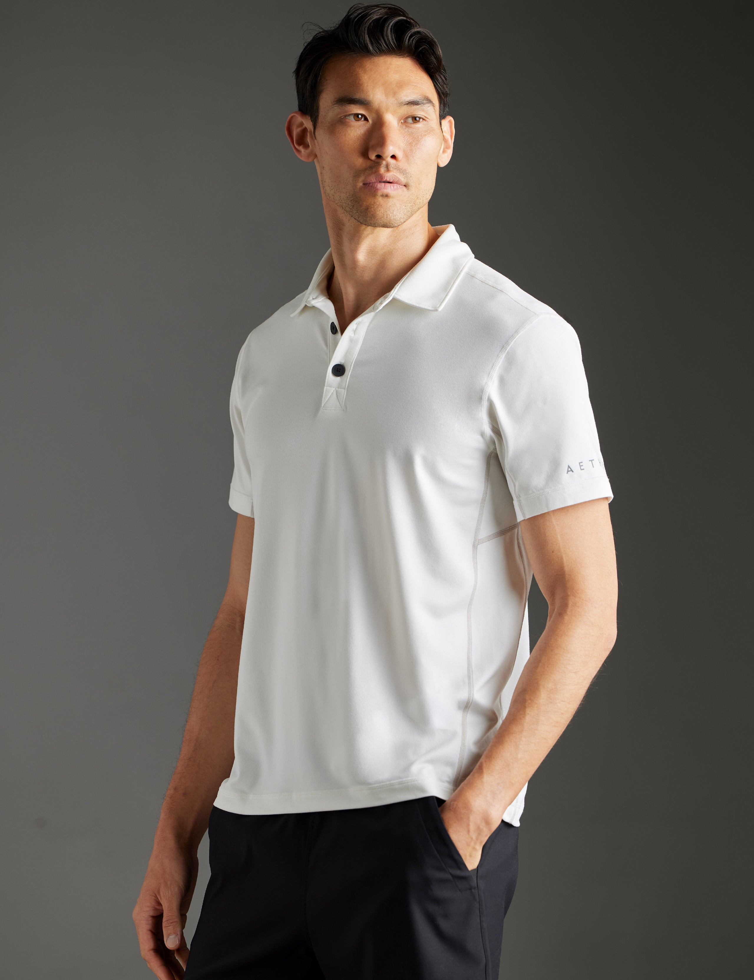Front 3/4 body view of man wearing Trek Articulated Polo in Natural White from AETHER Apparel.