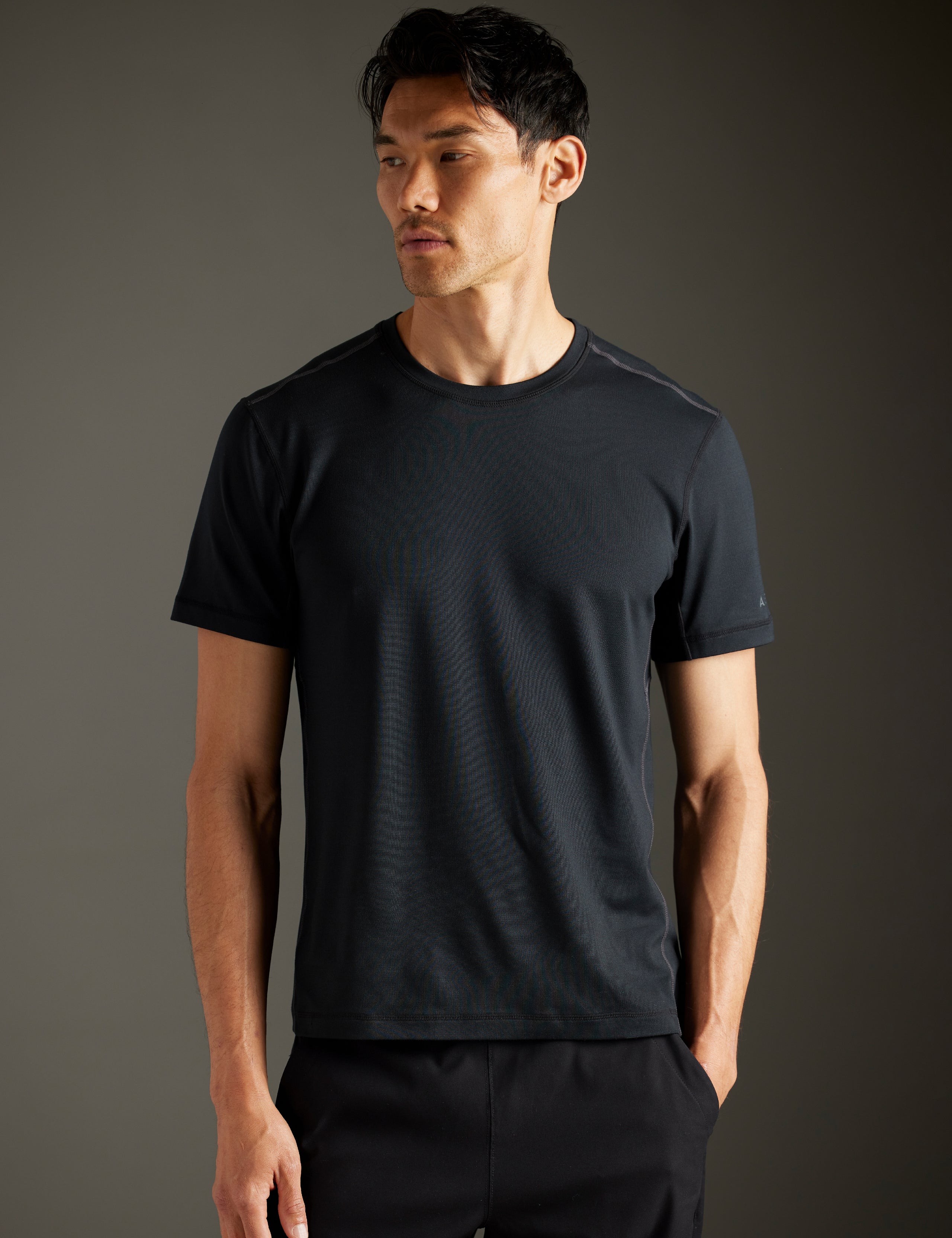 Front body view of man wearing Trek Articulated Tee in Onyx Black from AETHER Apparel.