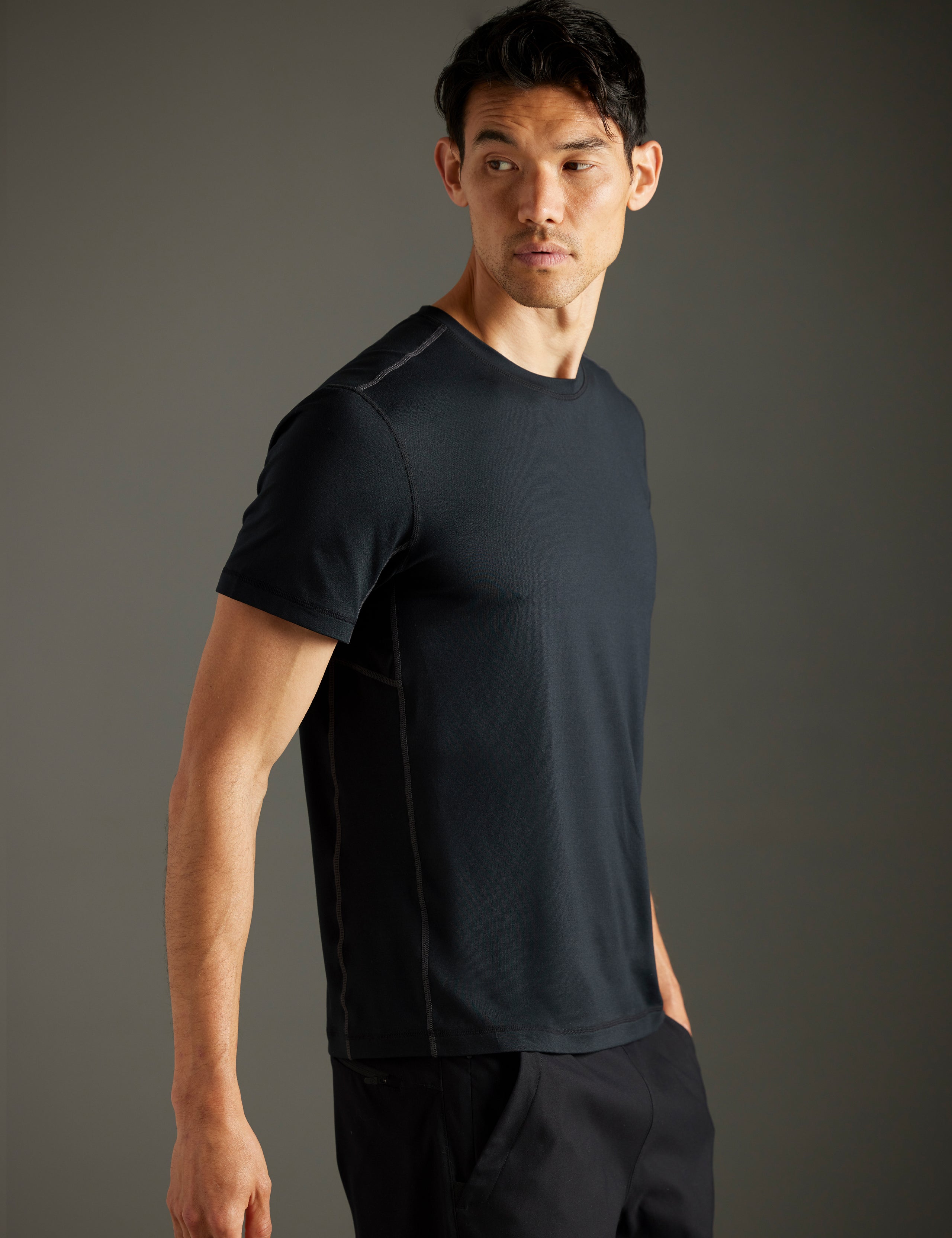 Front 3/4 body view of man wearing Trek Articulated Tee in Onyx Black from AETHER Apparel.