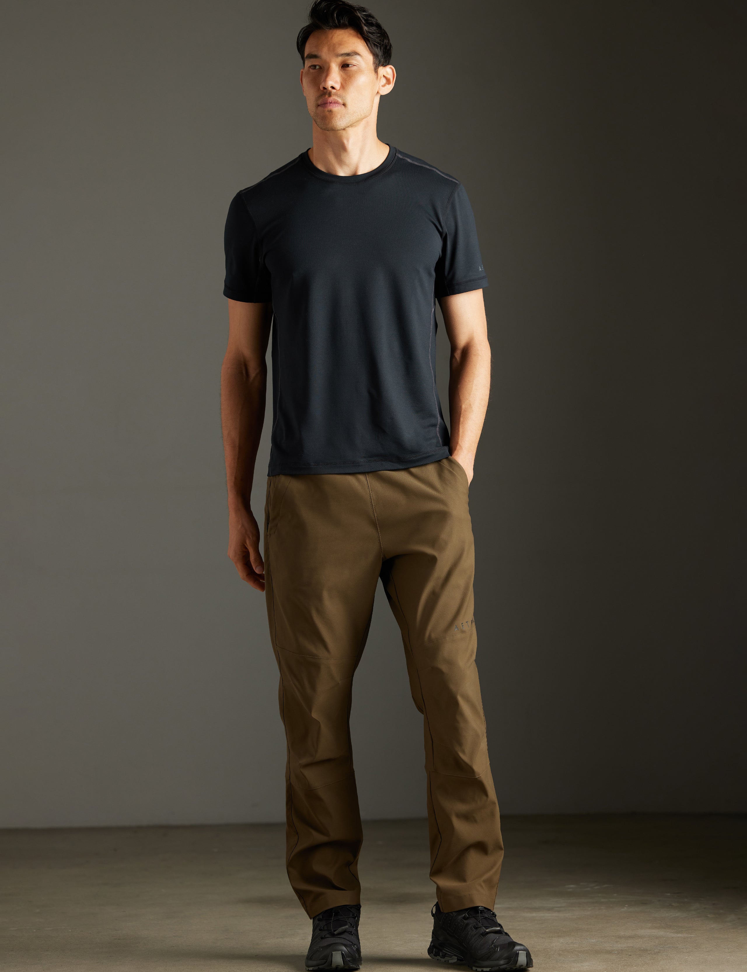 Front full-body view of man wearing Trek Articulated Tee in Onyx Black from AETHER Apparel.