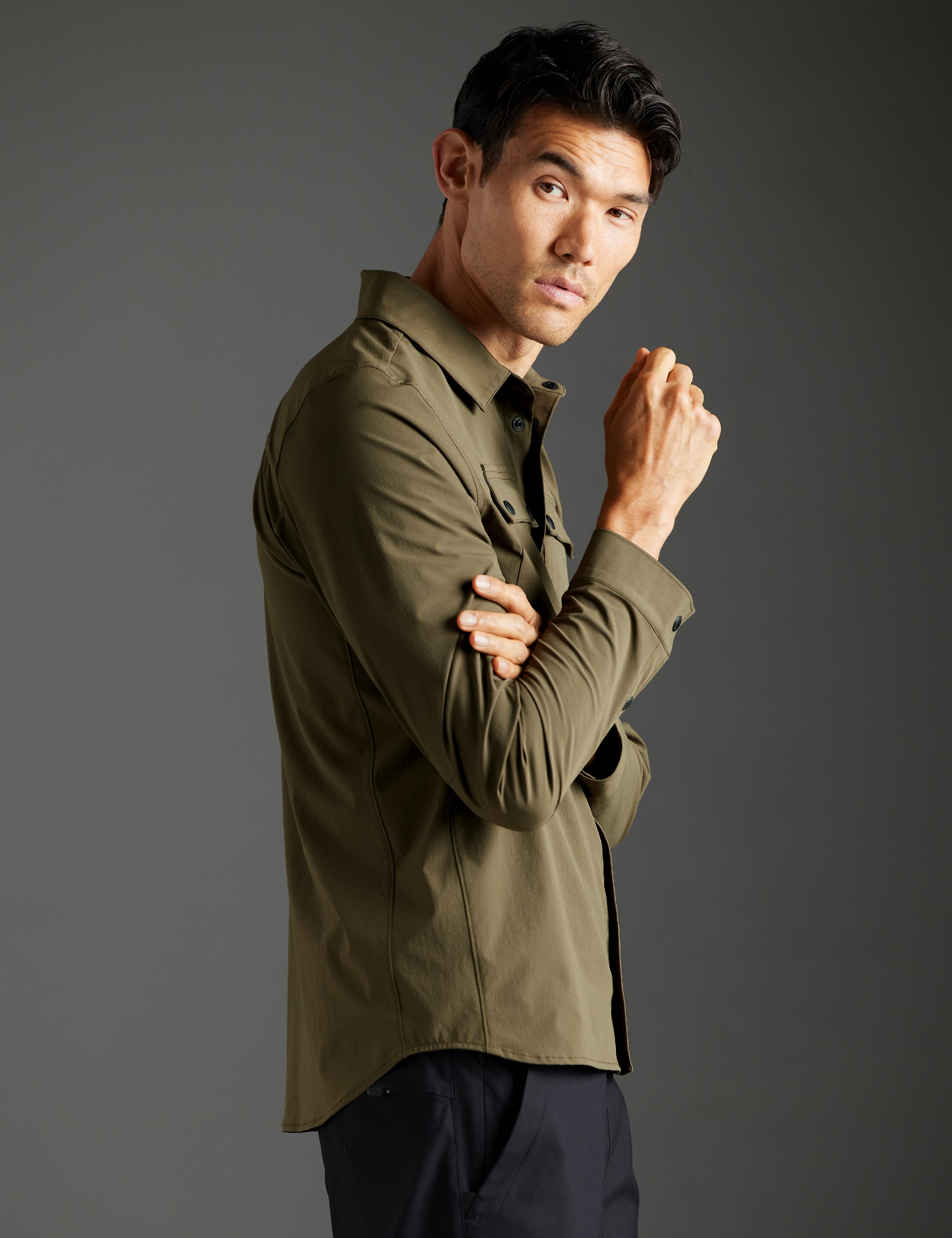 Side profile body view of man wearing Wonder Technical Button-Down in Cadet green from AETHER Apparel.