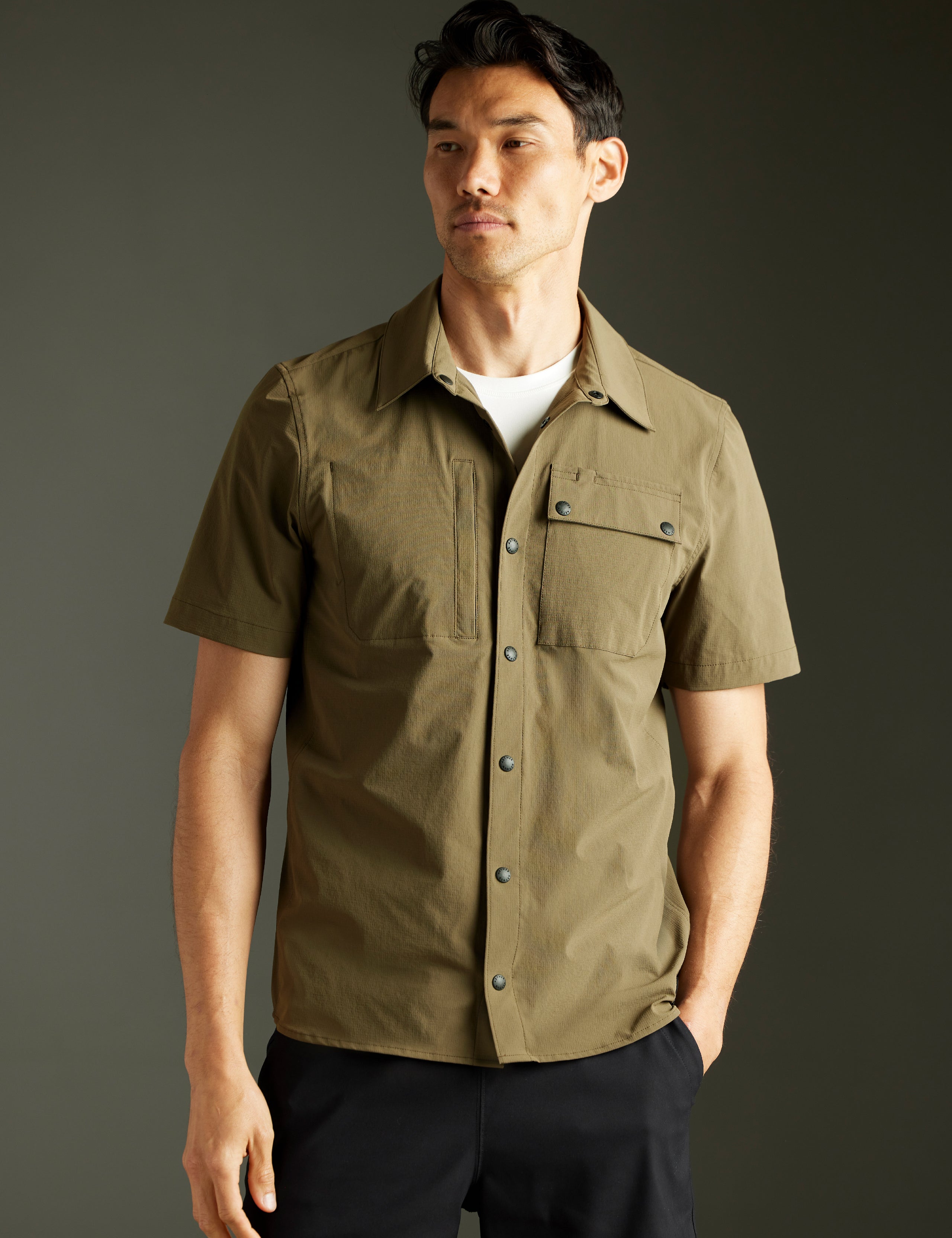 Front body view of man wearing Wonder Technical Short-Sleeve Button-Down in Cadet green from AETHER Apparel.