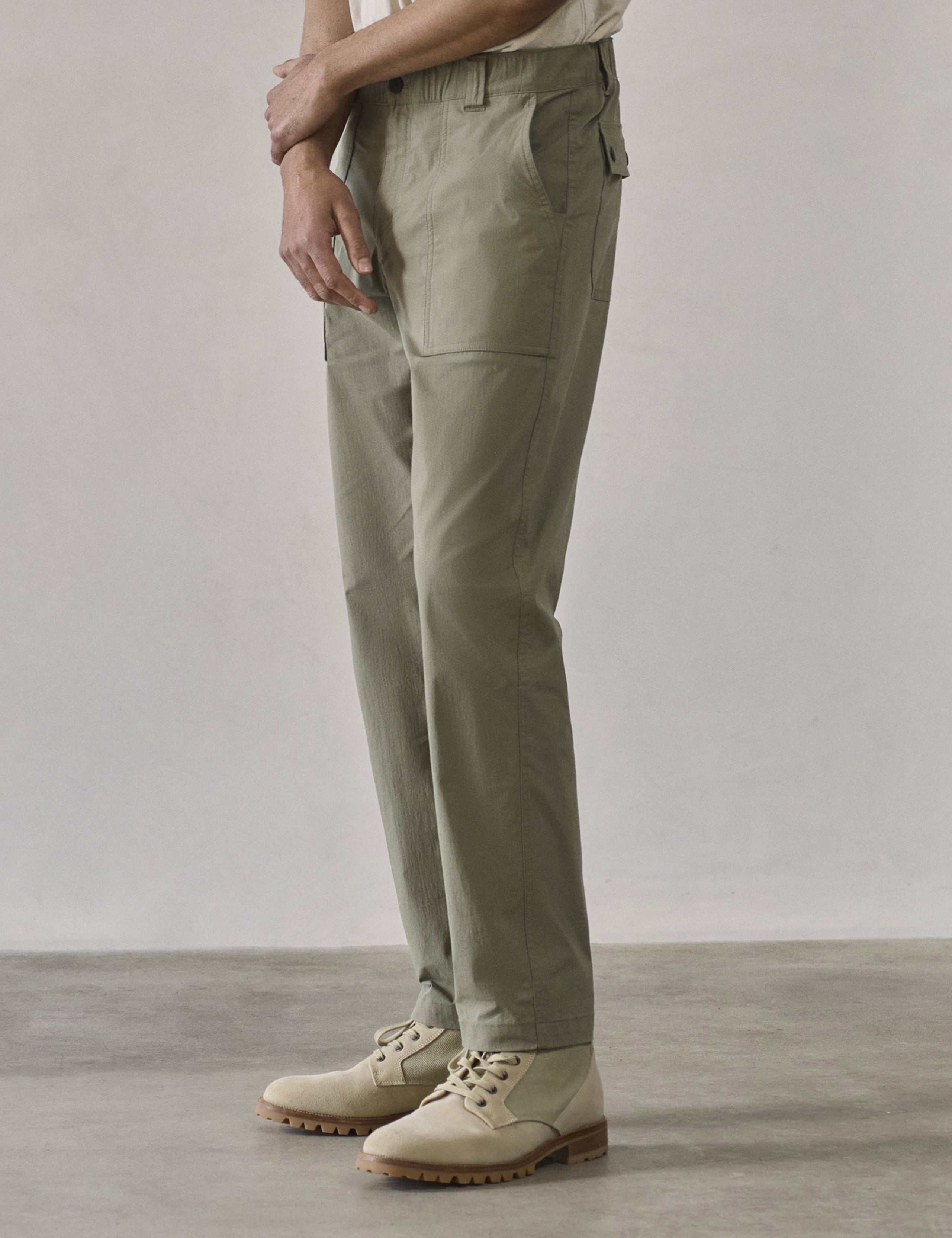 Front 3/4 lower body view of man wearing Zermatt Hiking Pant in Fern Green from AETHER Apparel.