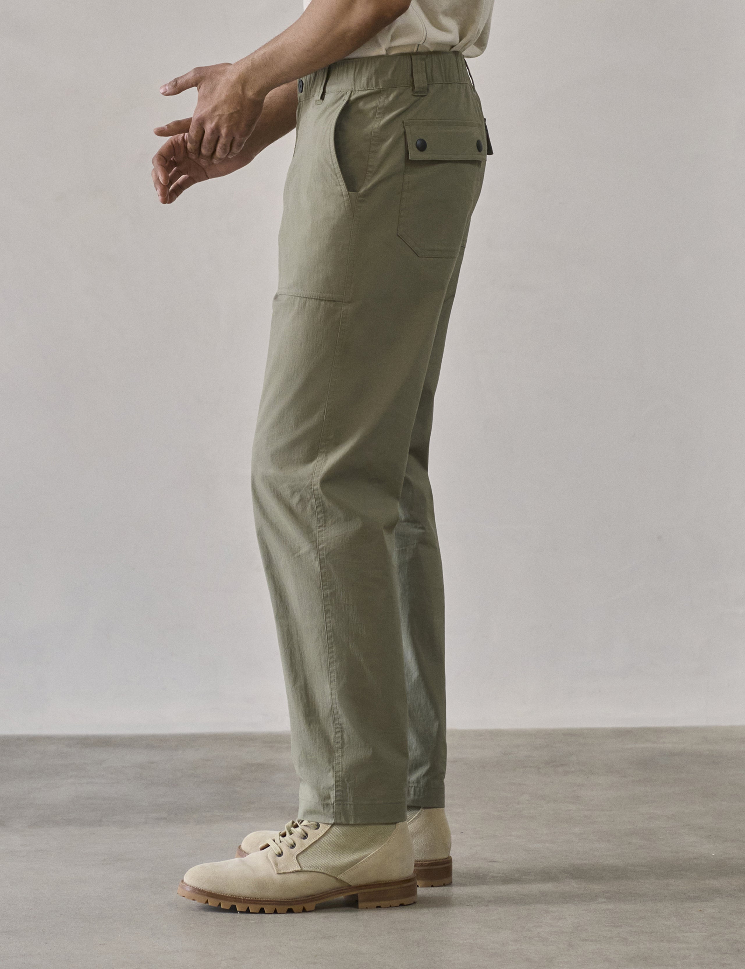 Side profile lower body view of man wearing Zermatt Hiking Pant in Fern Green from AETHER Apparel.