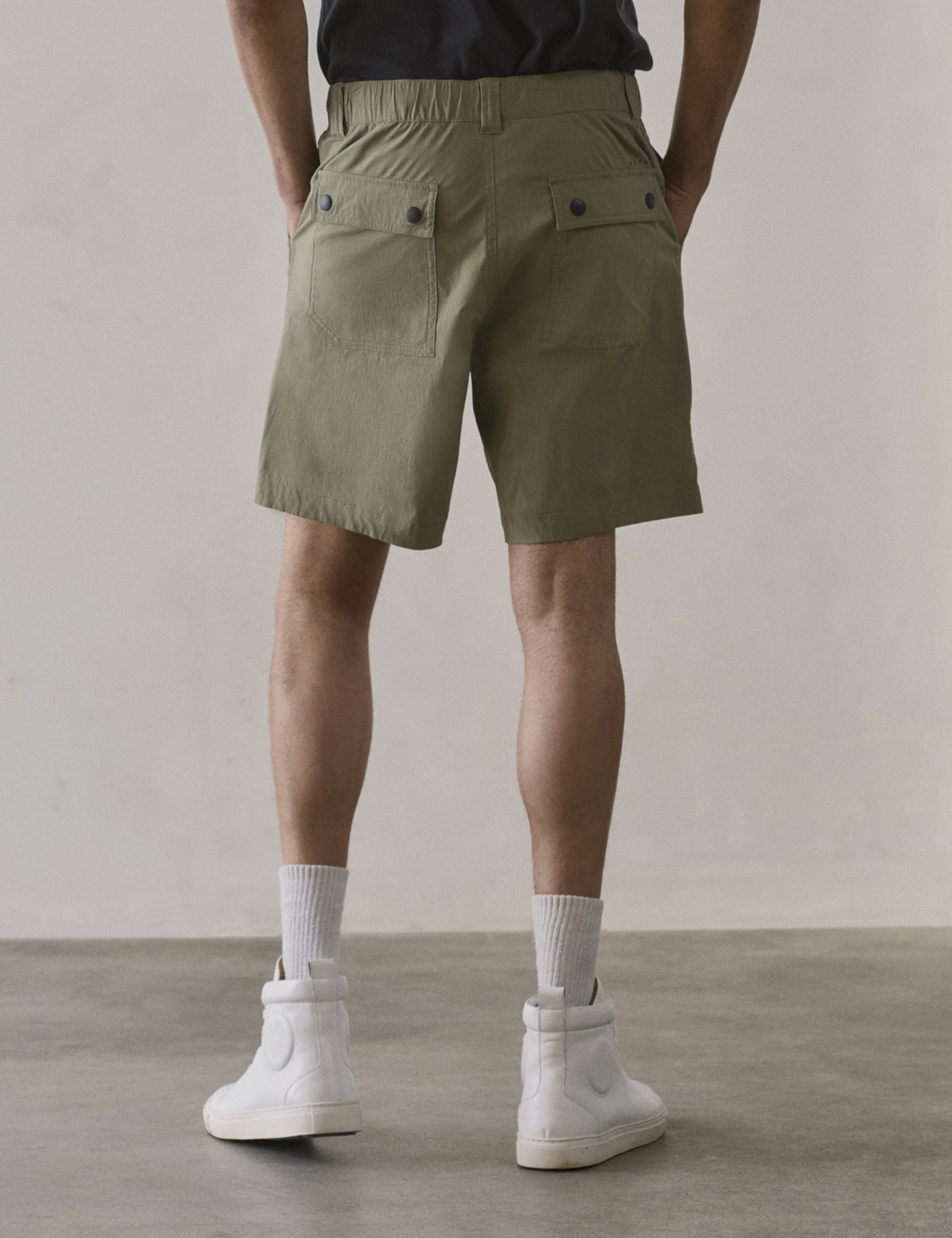 Rear lower body view of man wearing Zermatt Hiking Short in Fern Green from AETHER Apparel.