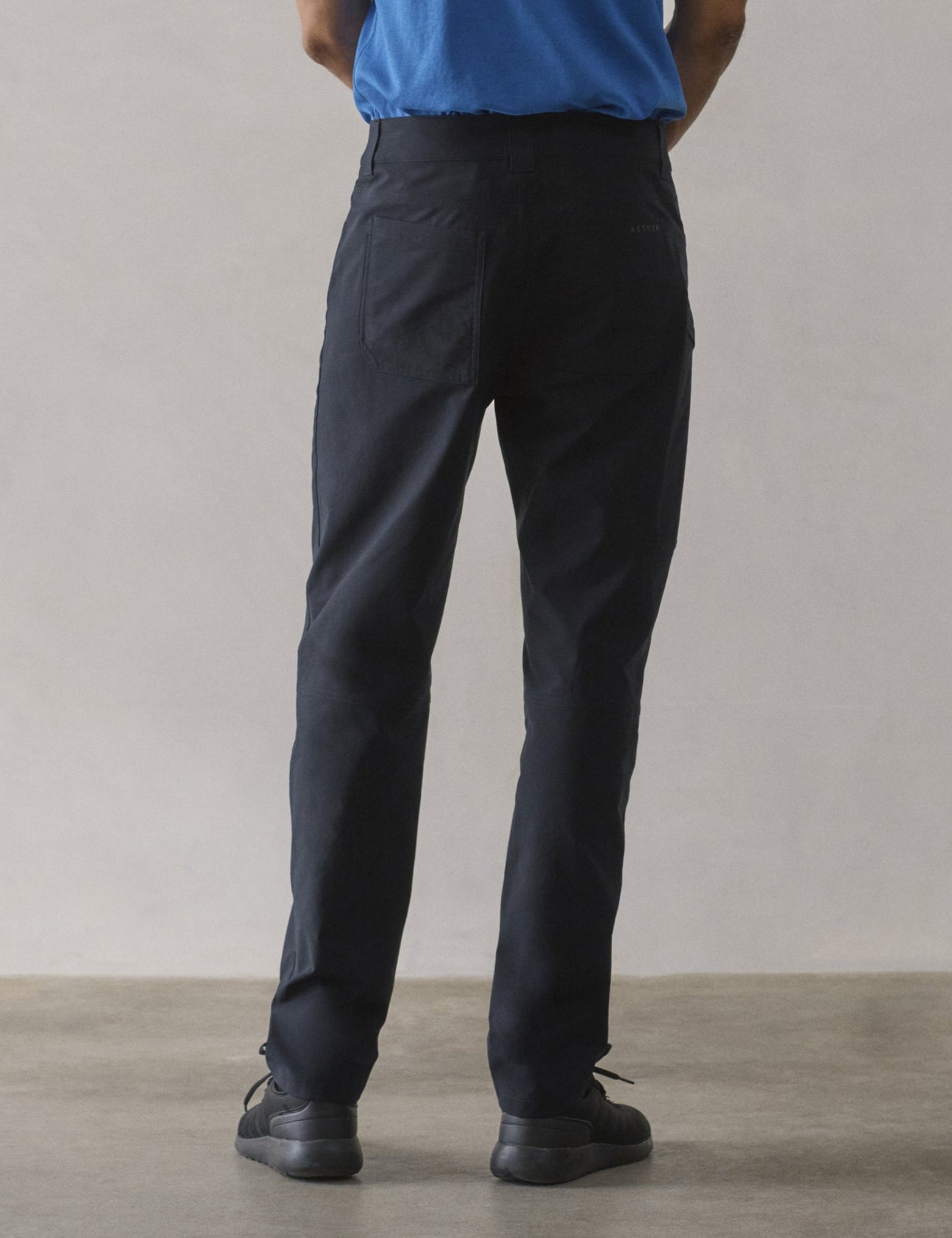 Rear lower-body view of man wearing Adventure Pant in Onyx Black from AETHER Apparel.