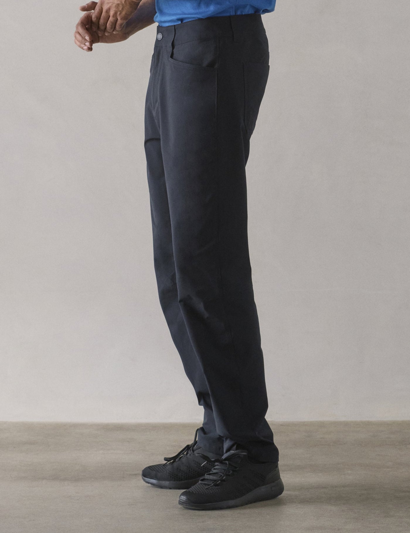 Side profile lower-body view of man wearing Adventure Pant in Onyx Black from AETHER Apparel.