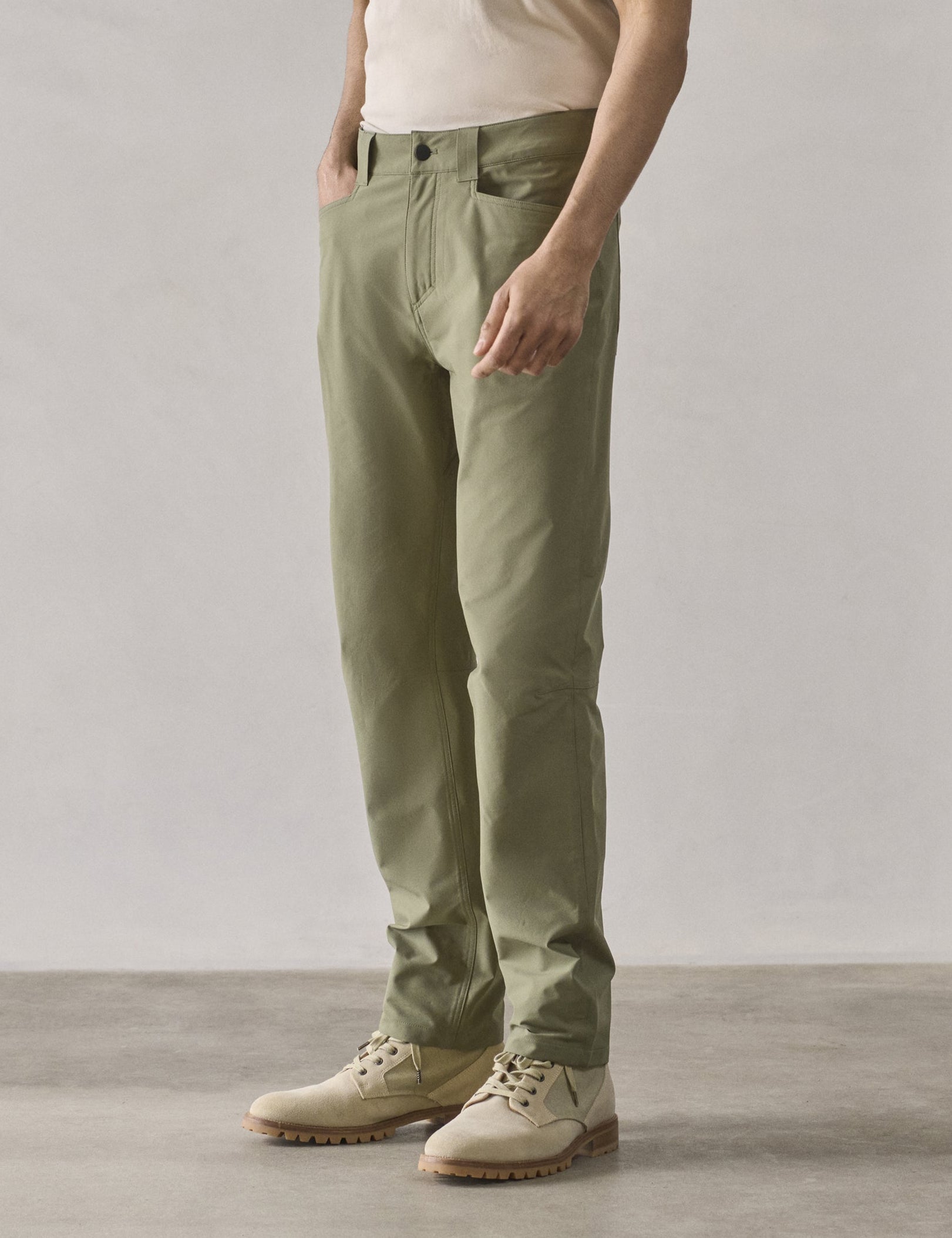 Front 3/4 lower-body view of man wearing Adventure Pant in Fern Green from AETHER Apparel.