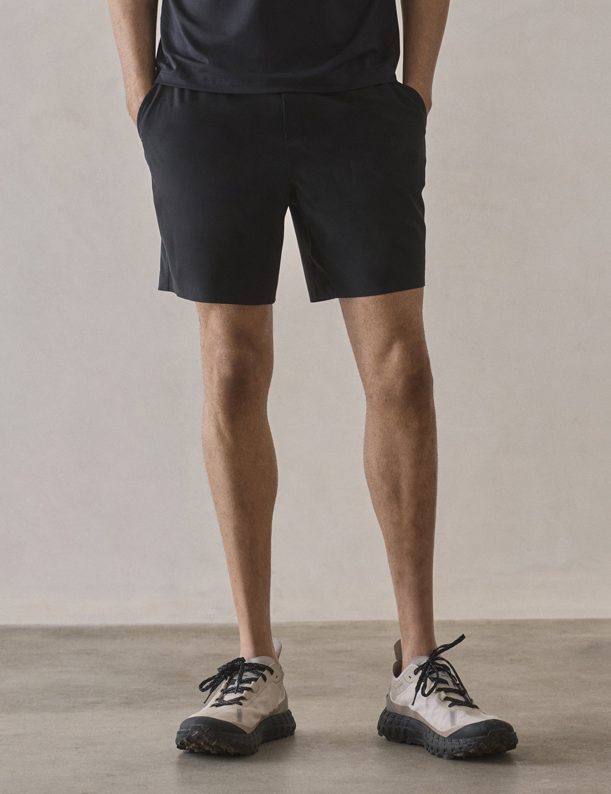 Front lower-body view of man wearing Rogue Hybrid Short in Onyx Black from AETHER Apparel.