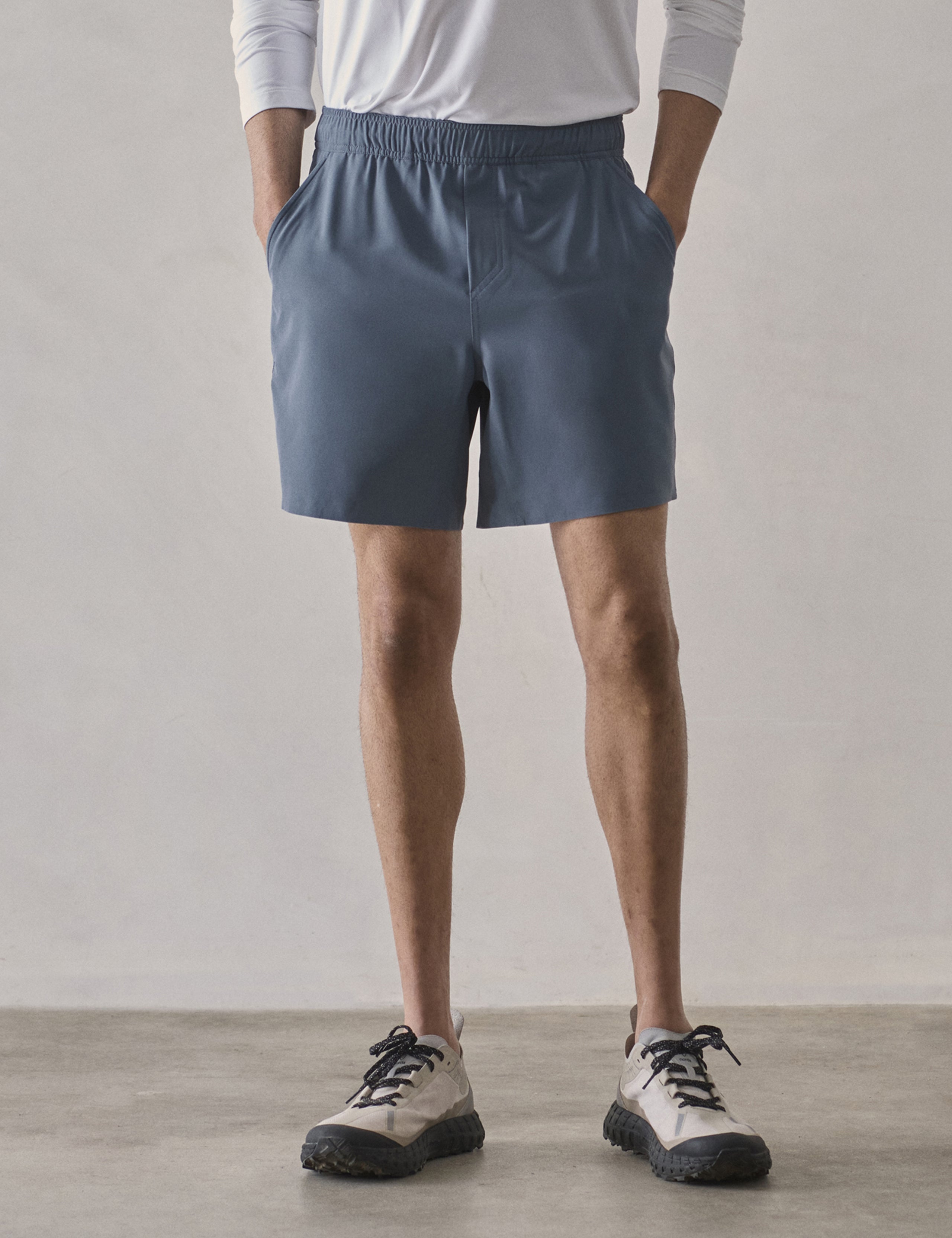 Front lower-body view of man wearing Rogue Hybrid Short in Portal Blue from AETHER Apparel.