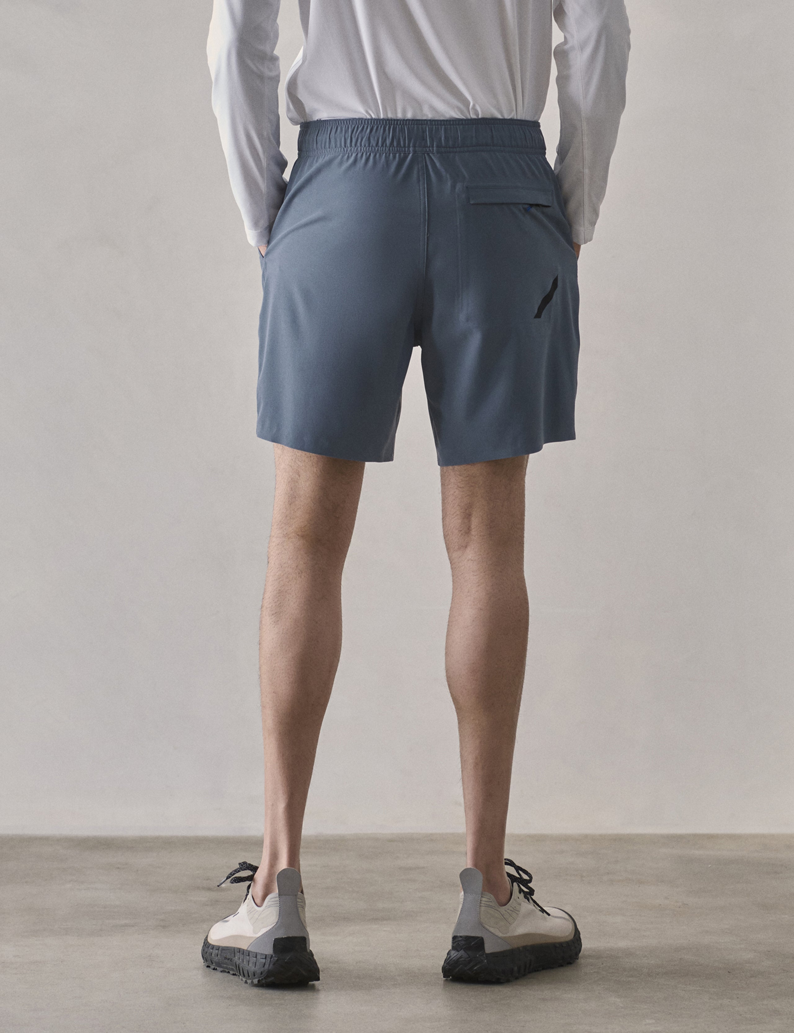 Rear lower-body view of man wearing Rogue Hybrid Short in Portal Blue from AETHER Apparel.